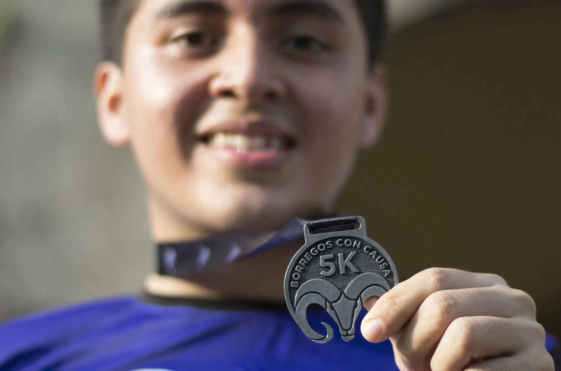 Reciben participantes medalla al finalizar la carrera.