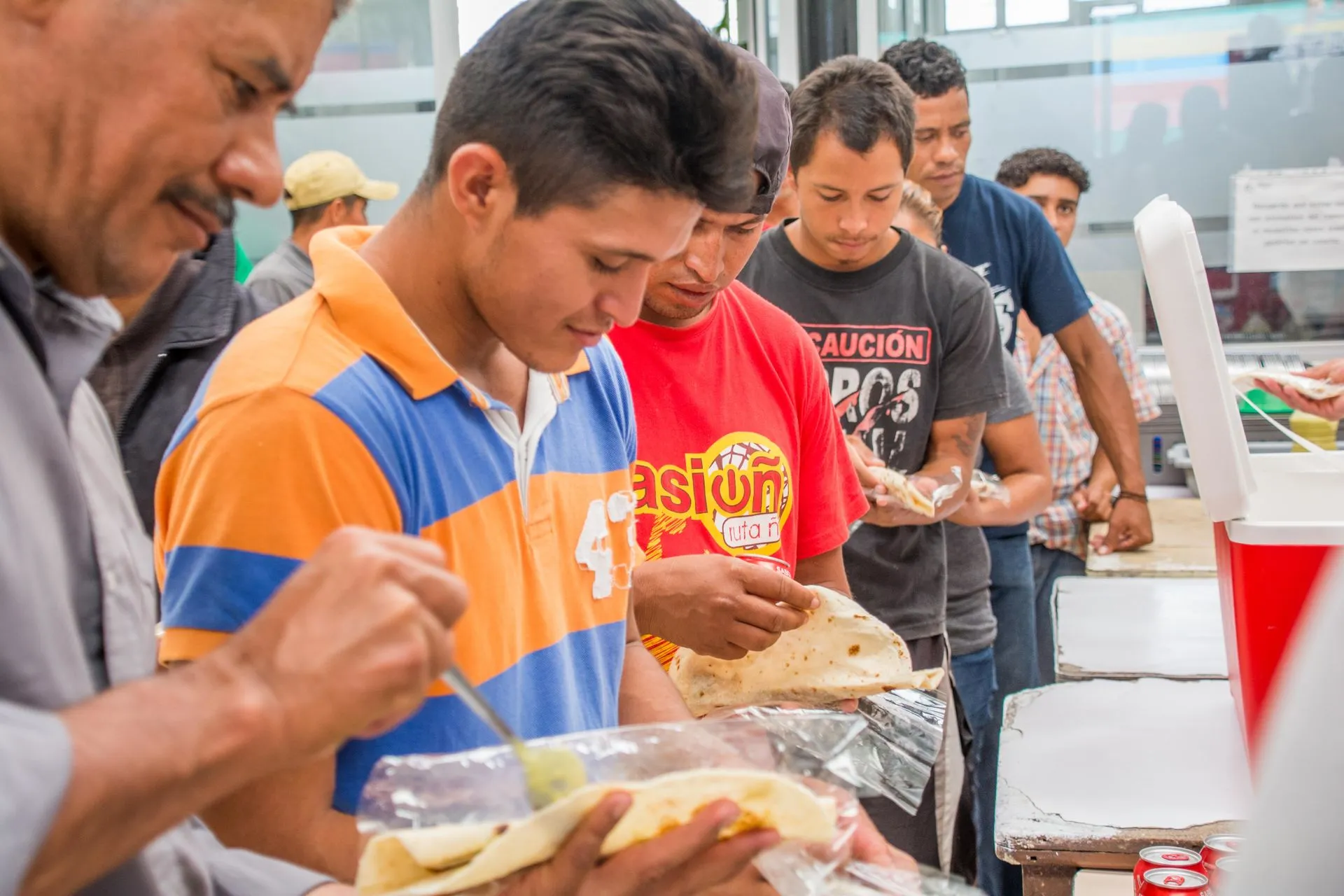 Migrantes con alimentos en las manos