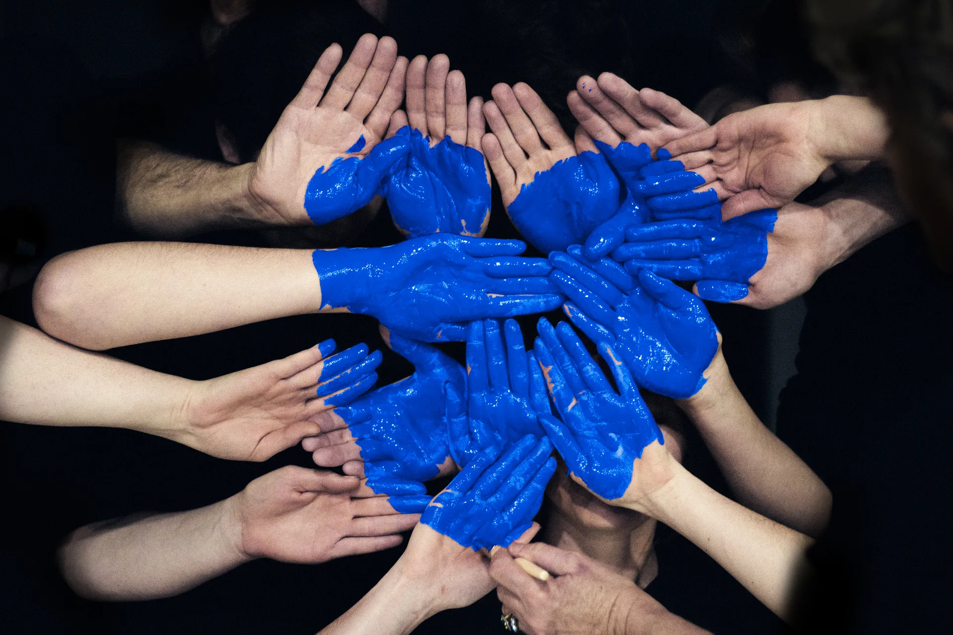 Manos juntas con pintura azul formando un corazón