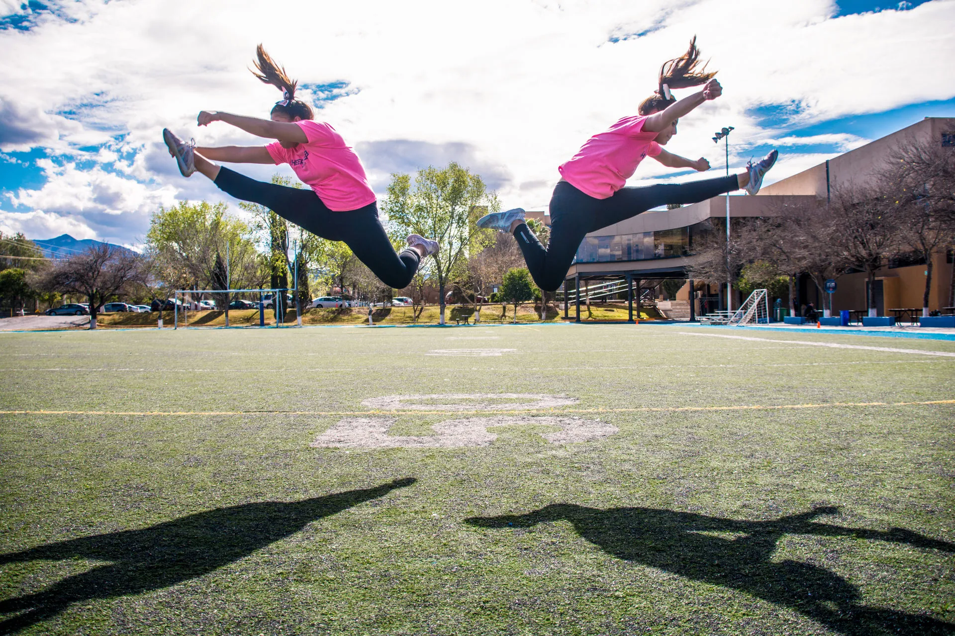Dos mujeres haciendo acrobacias en una cancha de fútbol americano