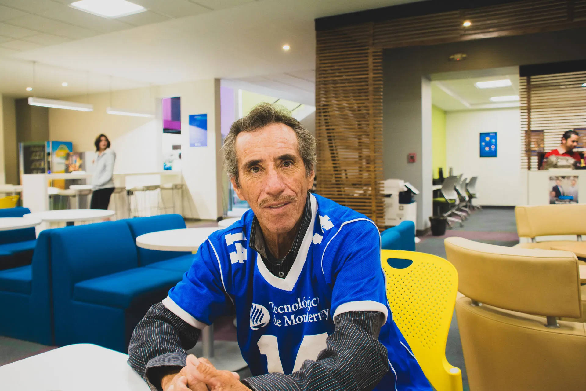 Señor volteando a la cámara, sentado en una silla. 