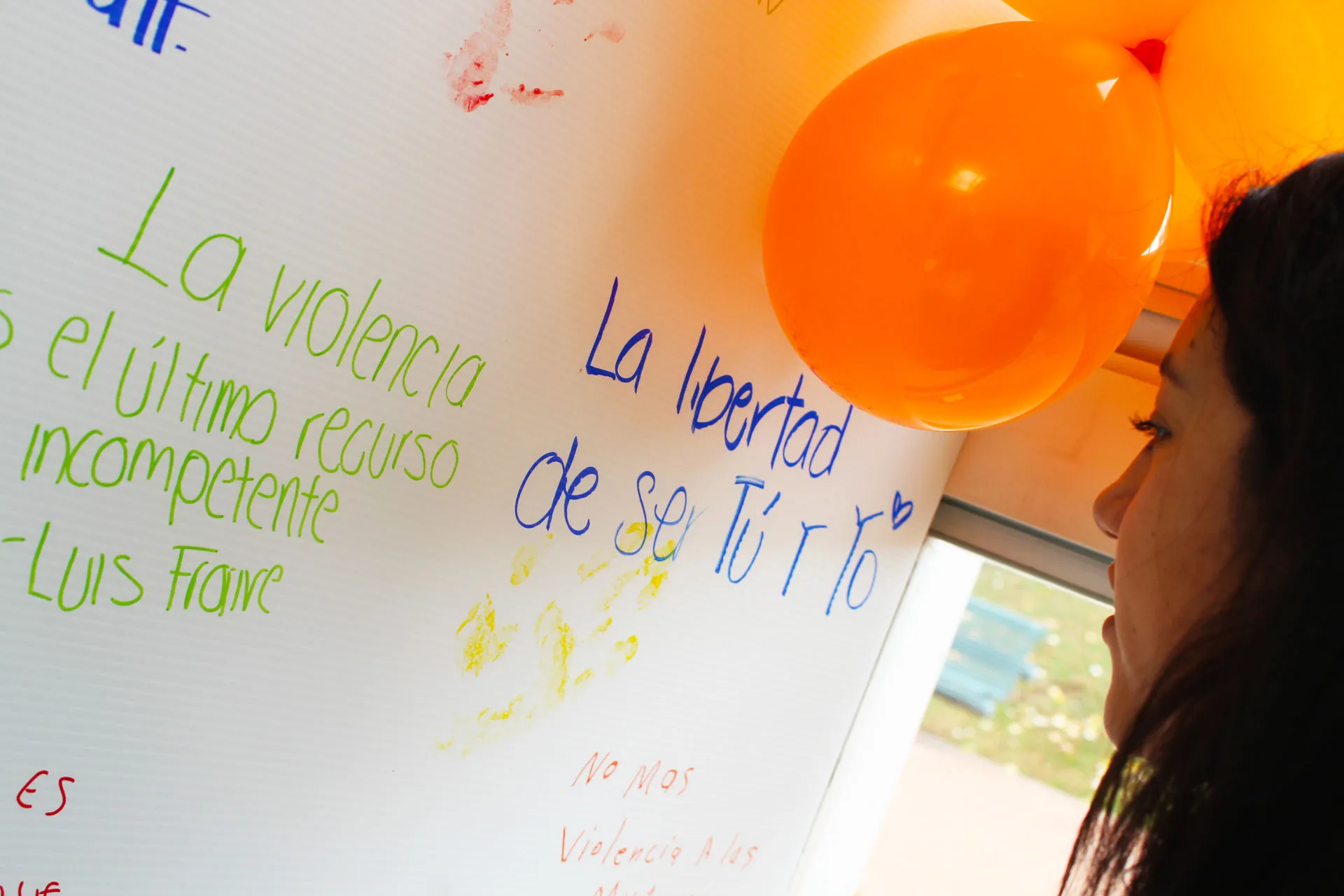Mujer frente a un mural del Orange Day