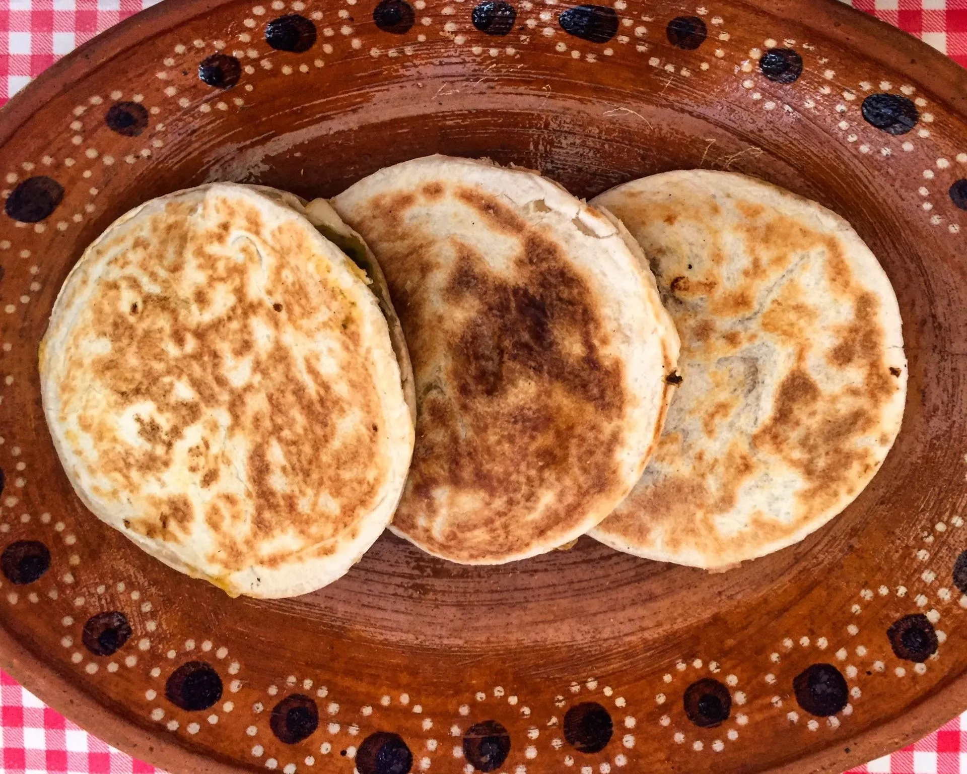 Foto de gorditas de azúcar en un plato de barro sobre una mesa