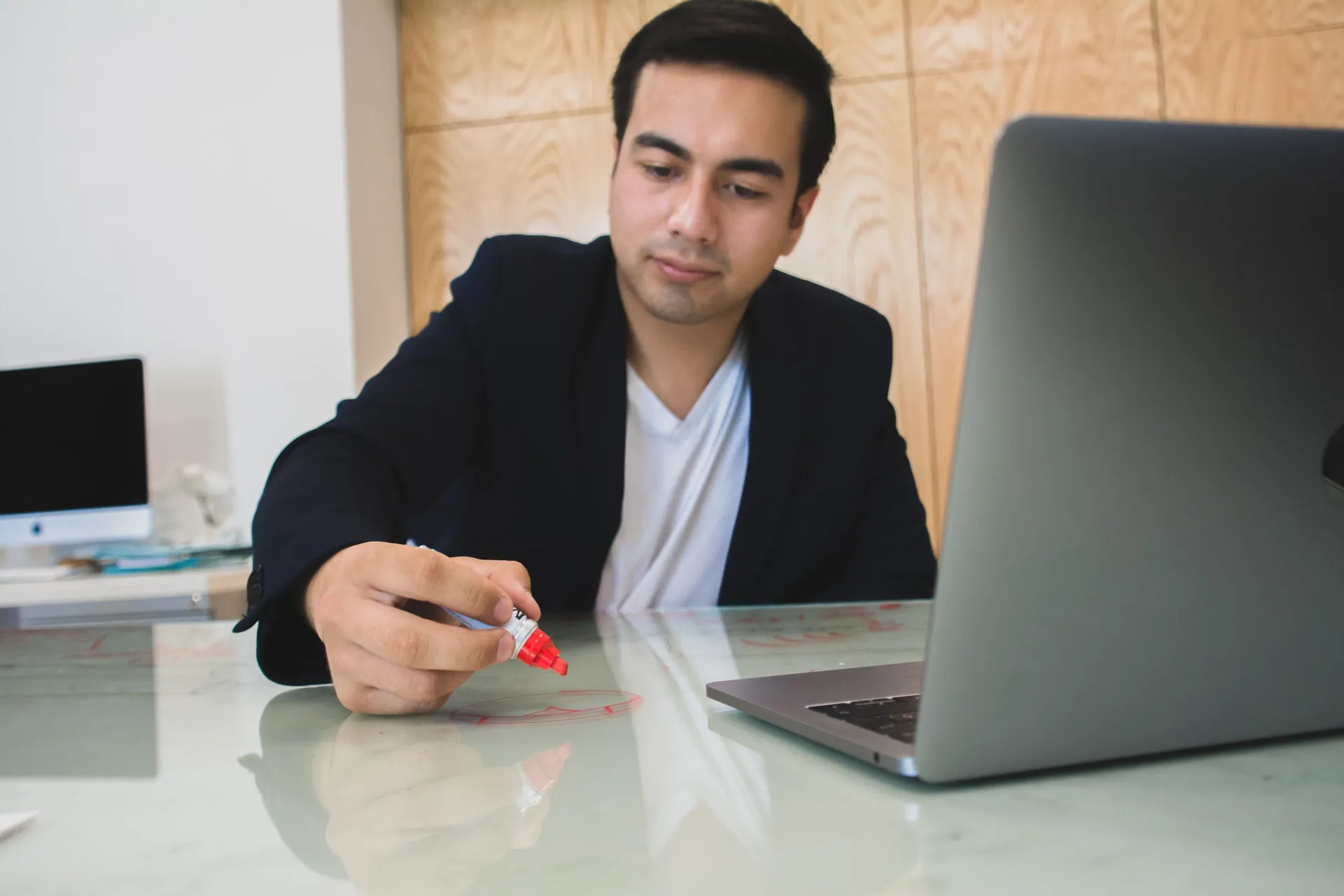Jóven escribiendo en una mesa de vidrio