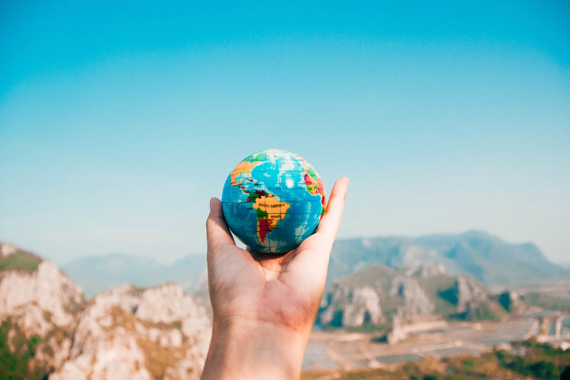 Joven sosteniendo un globo terráqueo 
