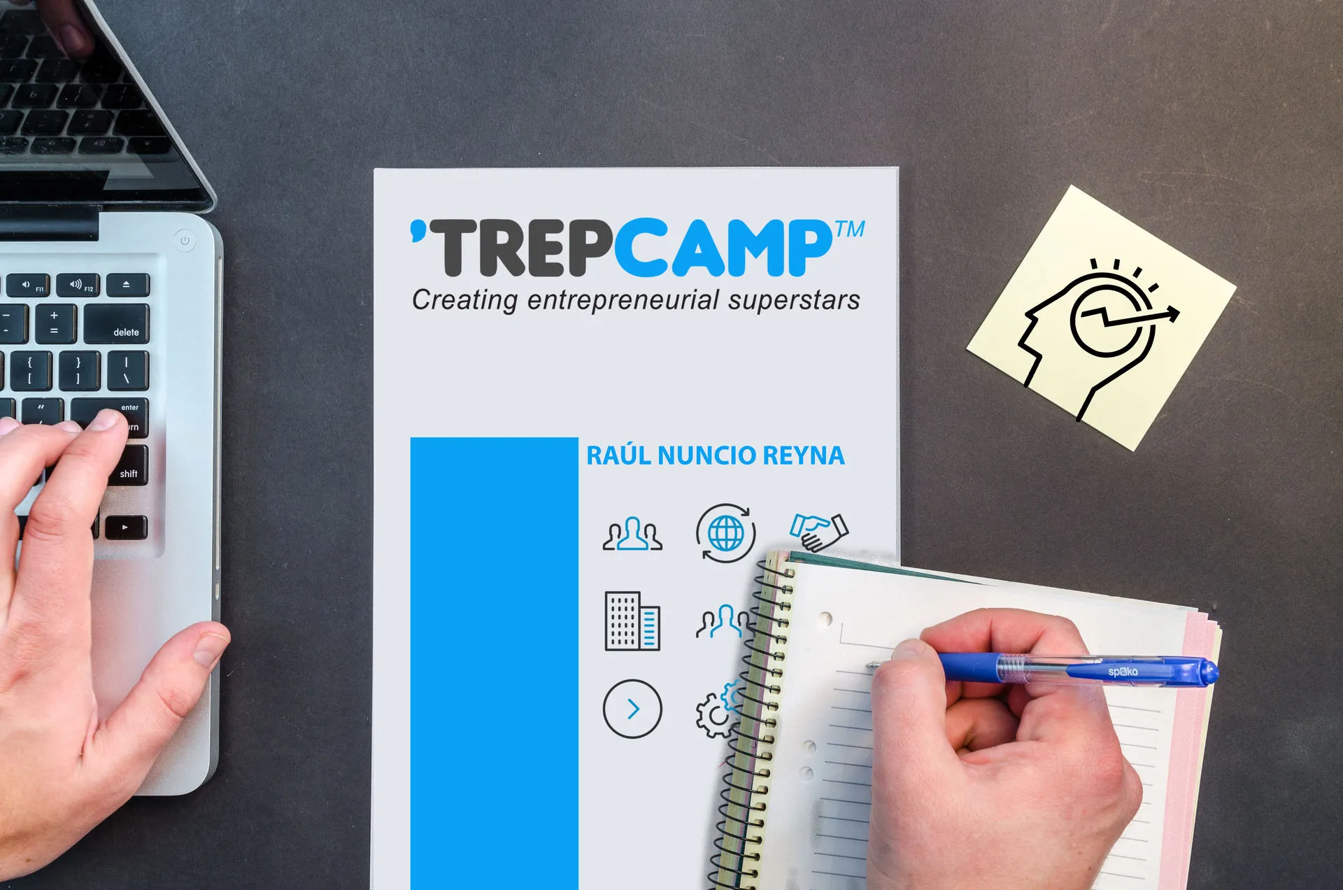 Escritorio con un cuaderno y una laptop. 