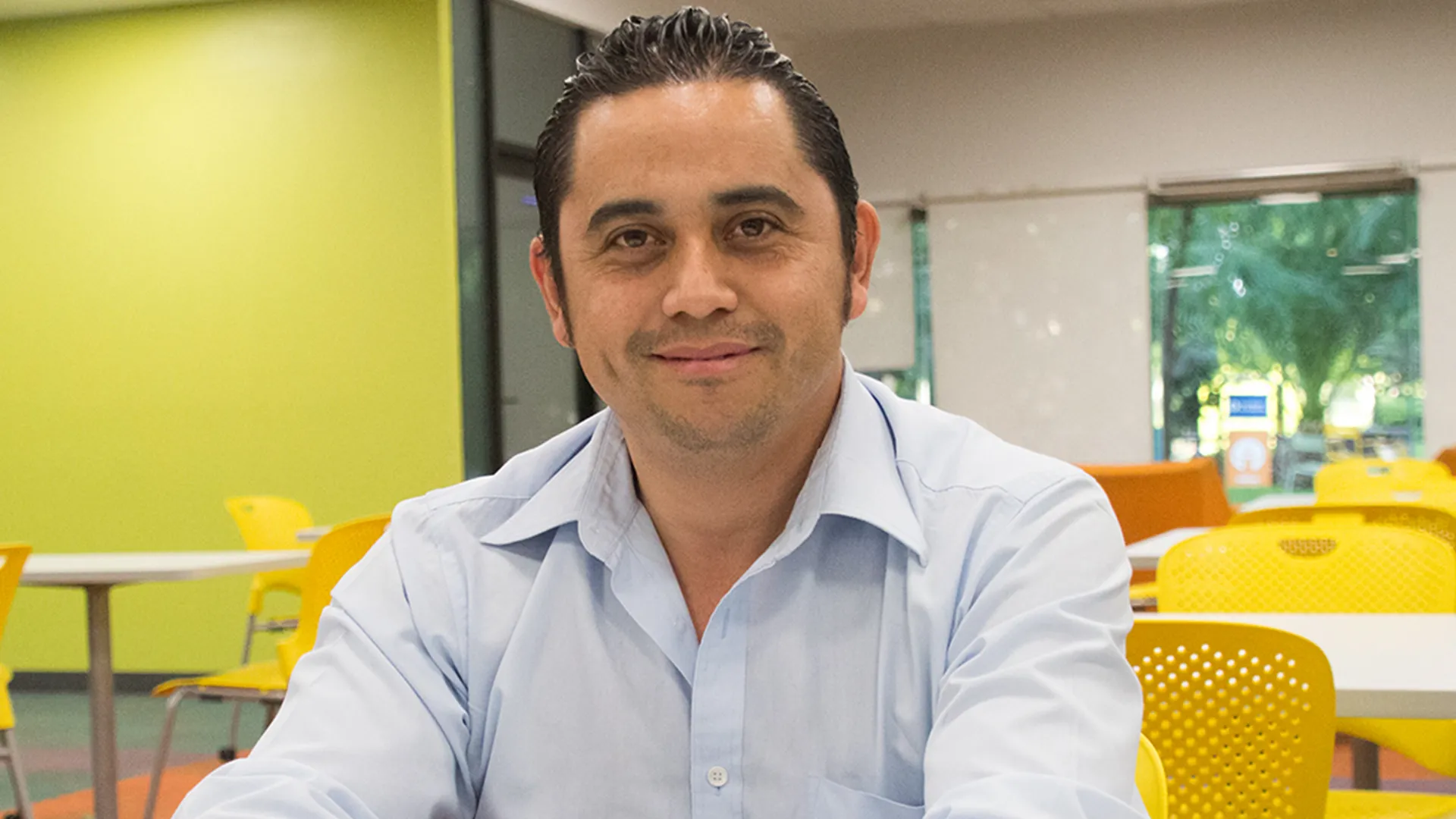 Hombre sentado sonriendo a la cámara