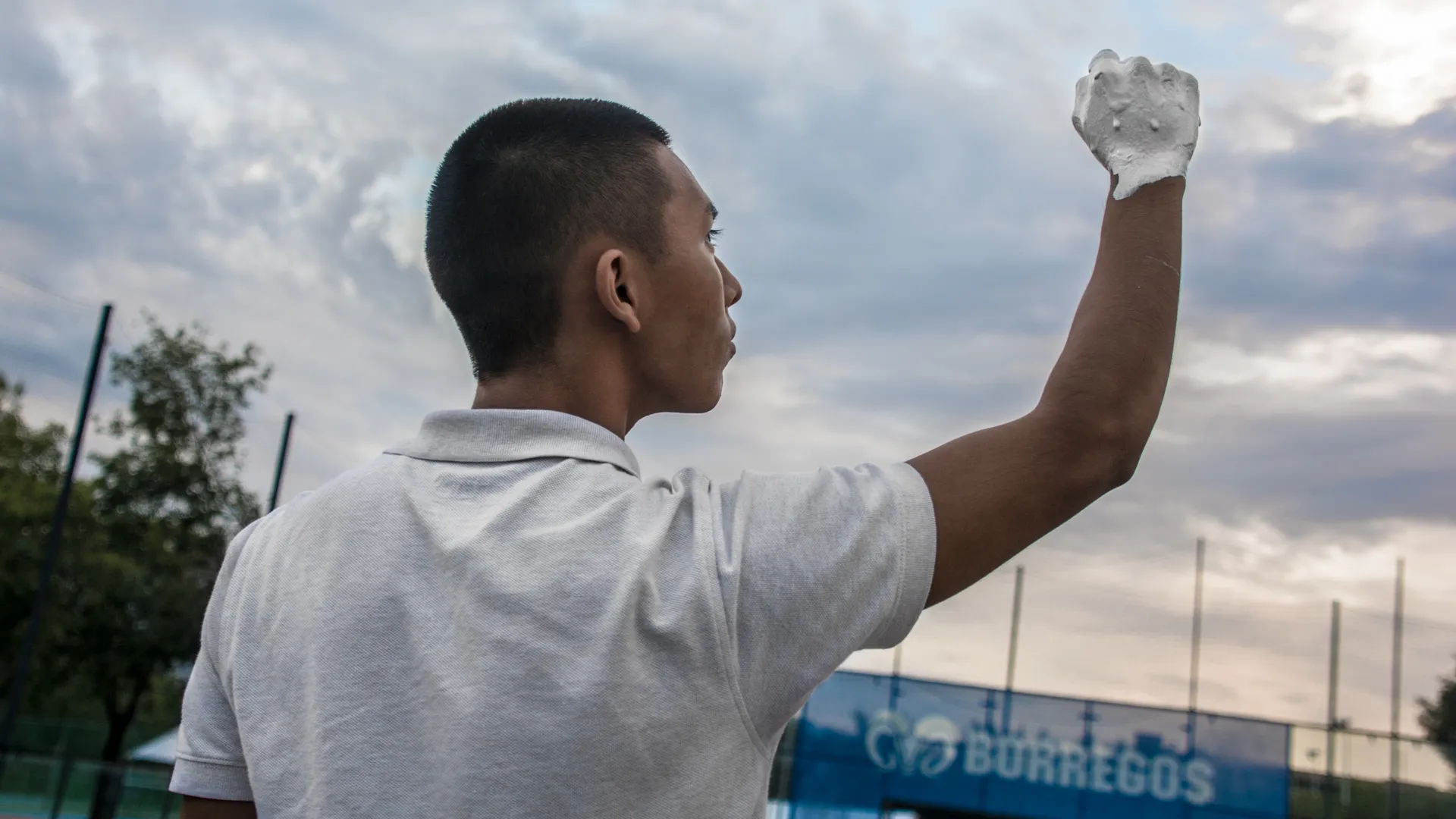 Alumno alzando su mano pintada en blanco