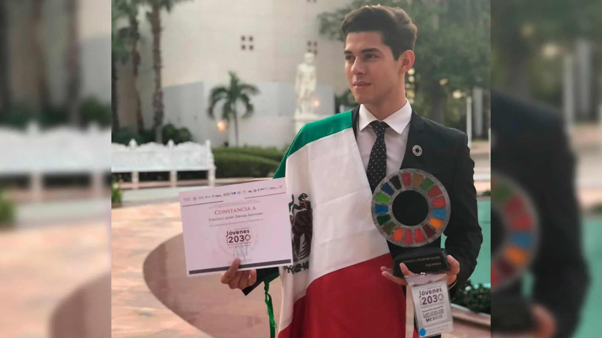 Paco Zamora, foto de ganador, con su premio, reconocimiento y bandera de México.
