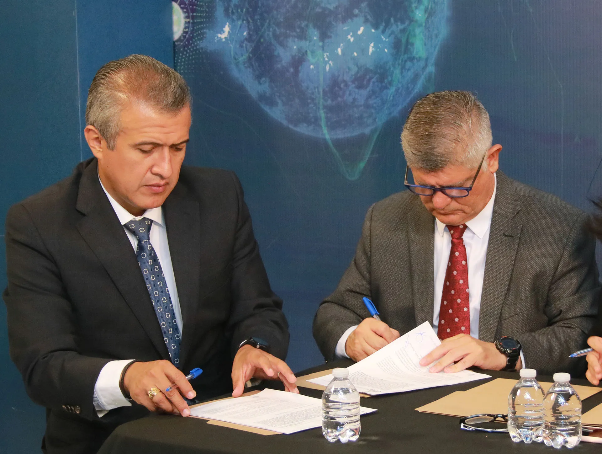 Profesores firmando convenio