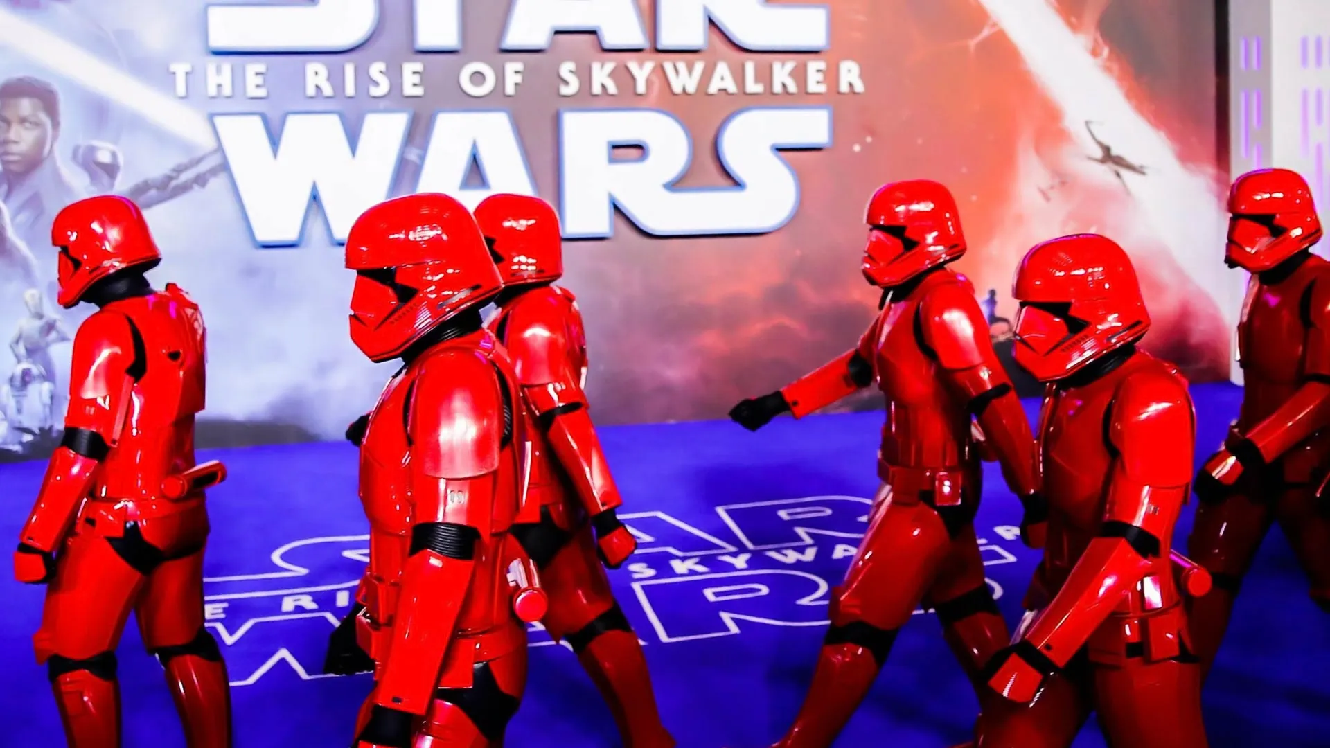 Stormtroopers desfilando con poster de starwars al fondo