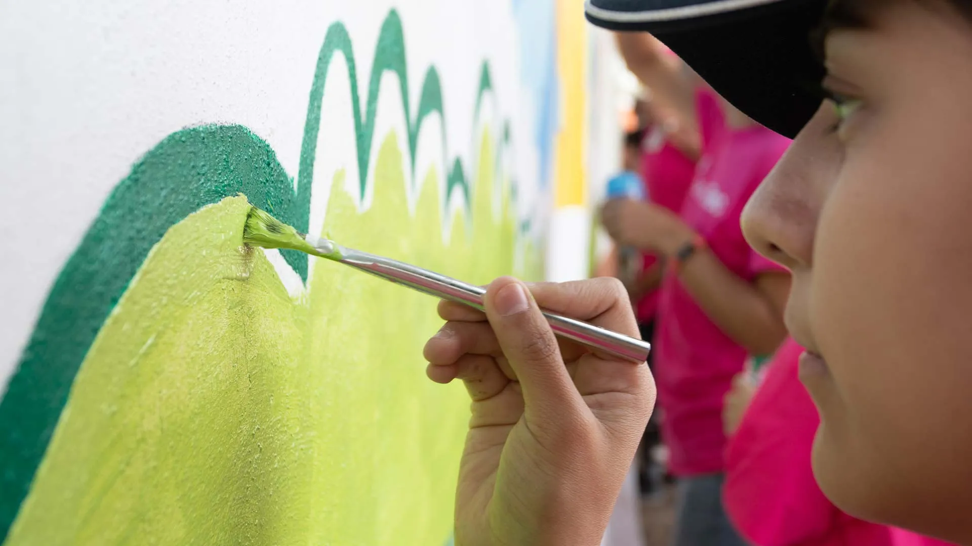 Voluntarios pintan barda en escuela de Pachuca