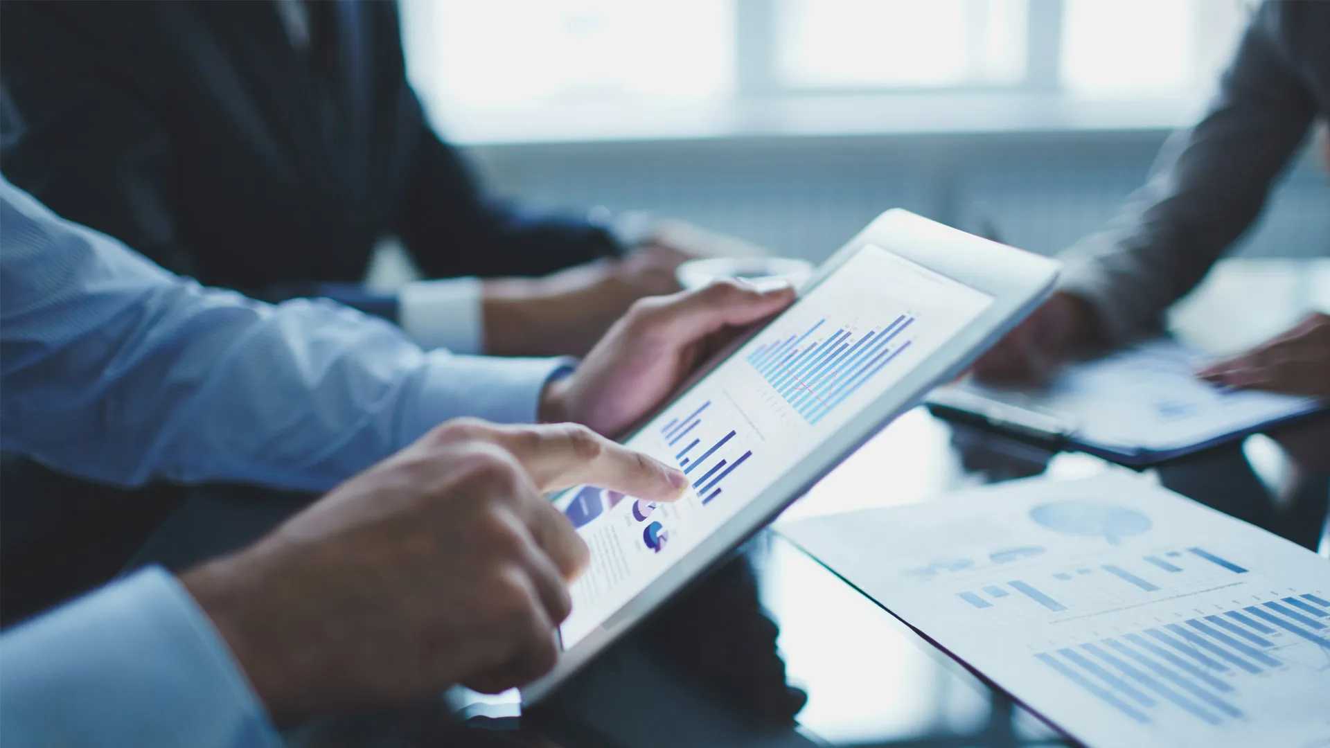 hombre señalando una tableta con graficos