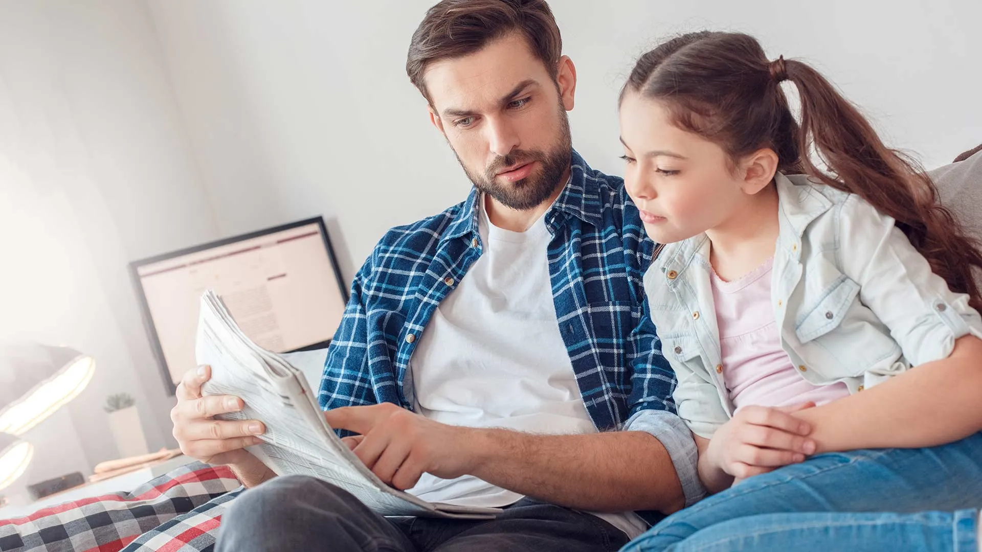 Papá explicando una noticia del periódico a su hija