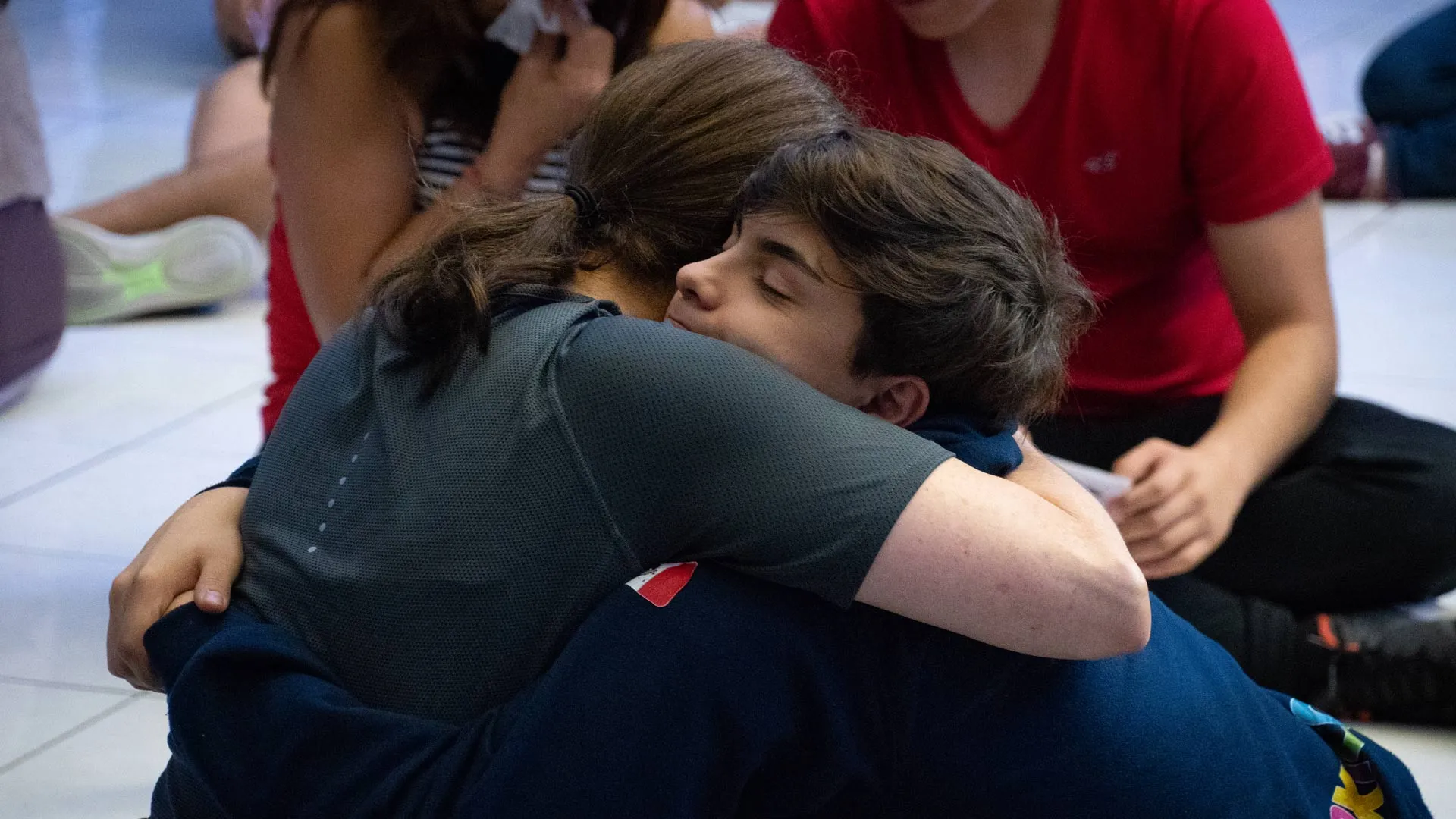 Madre de familia y alumno se abrazan