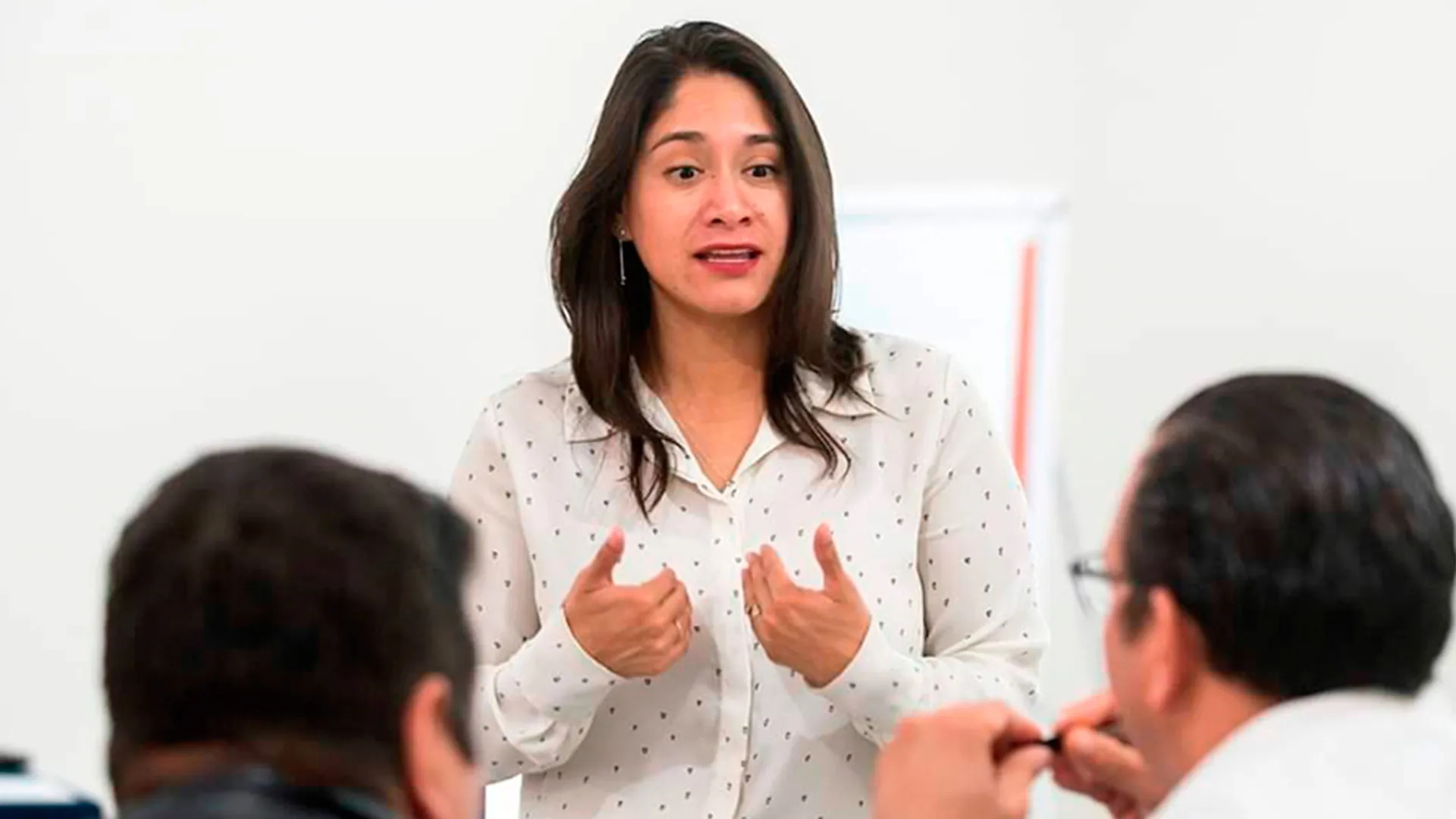 Alondra dando una plática a hombres