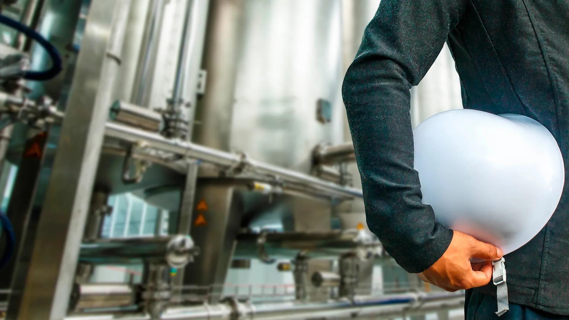 Trabajador sosteniendo un casco, dentro de una planta