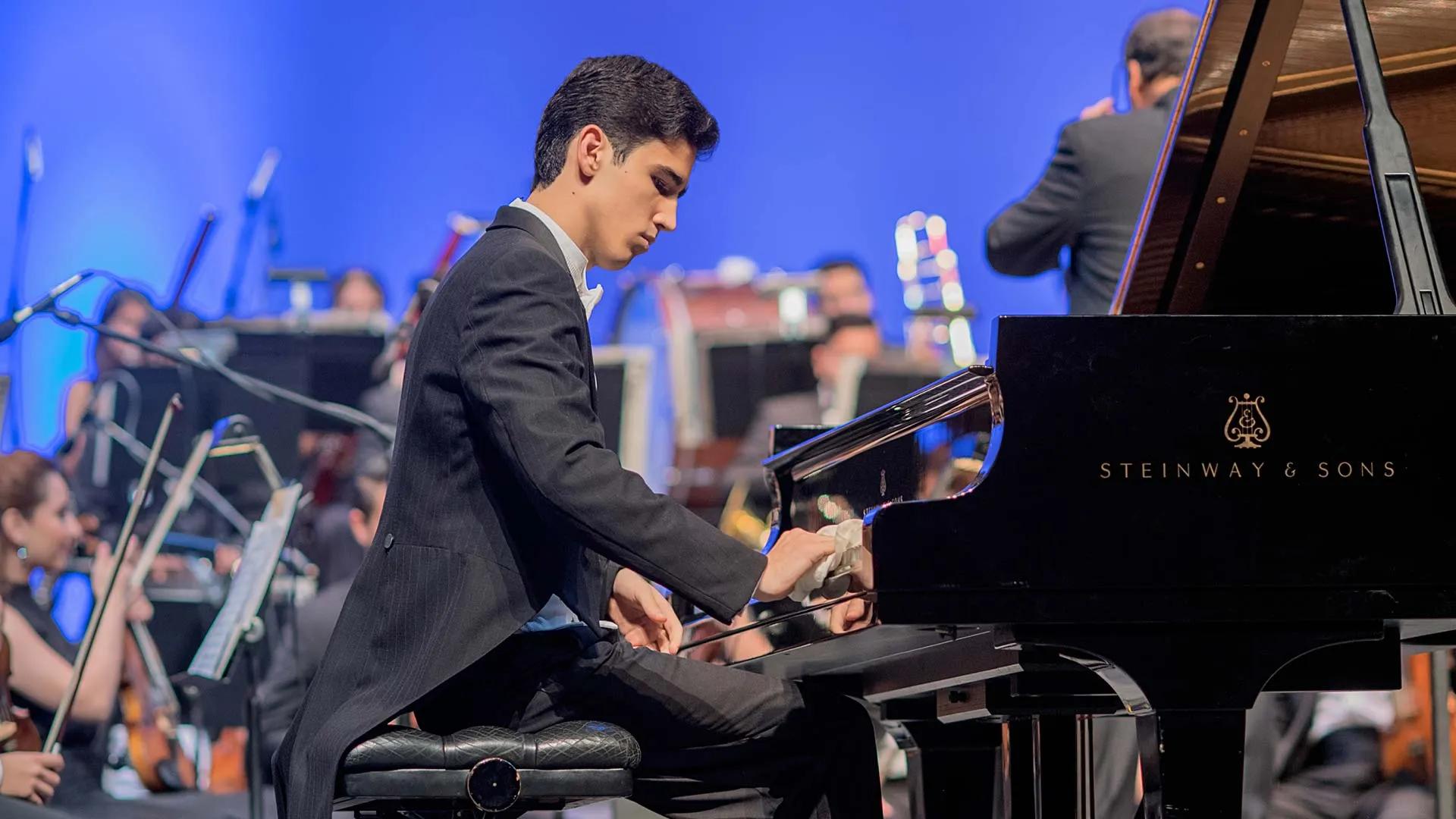 joven sentado tocando un piano