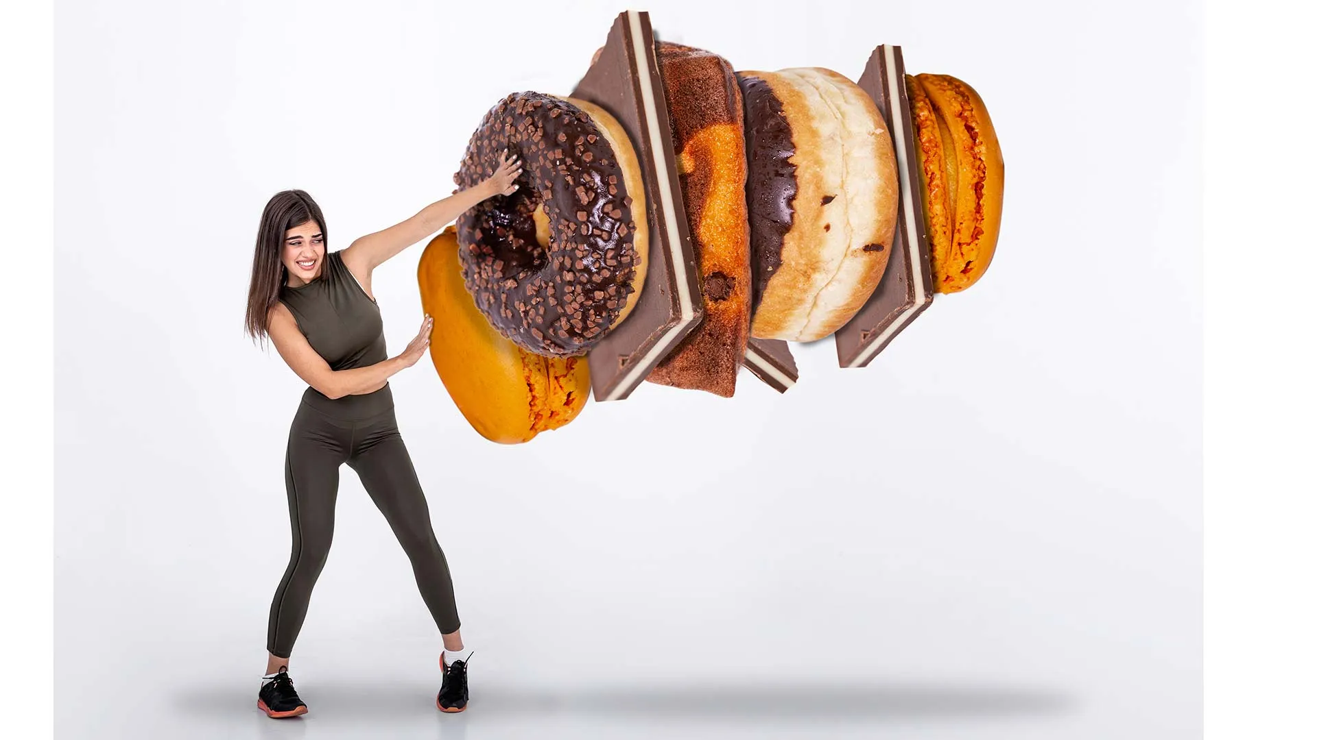 Imagen conceptual de chica luchando contra unas donas gigantes y chocolates de comida