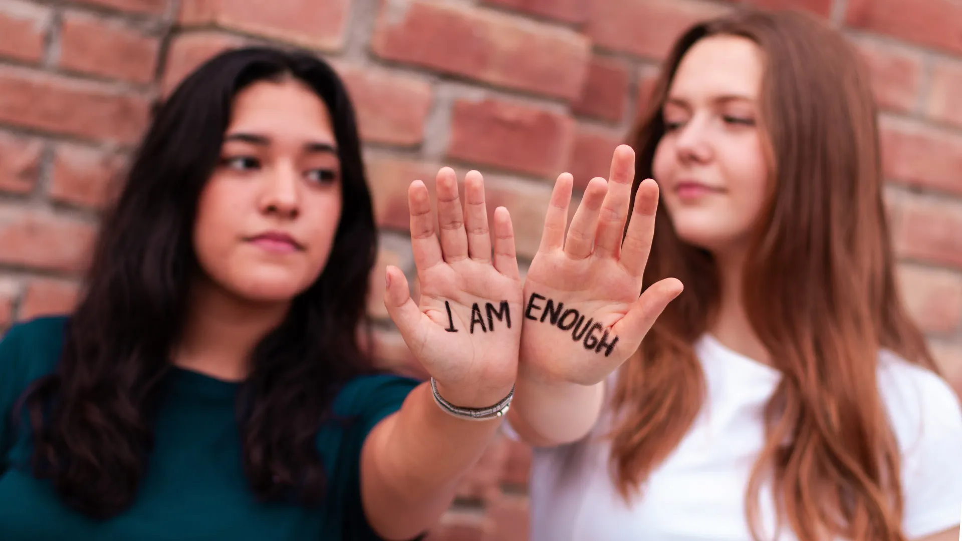 Alumnas mostrando frase escrita en sus manos