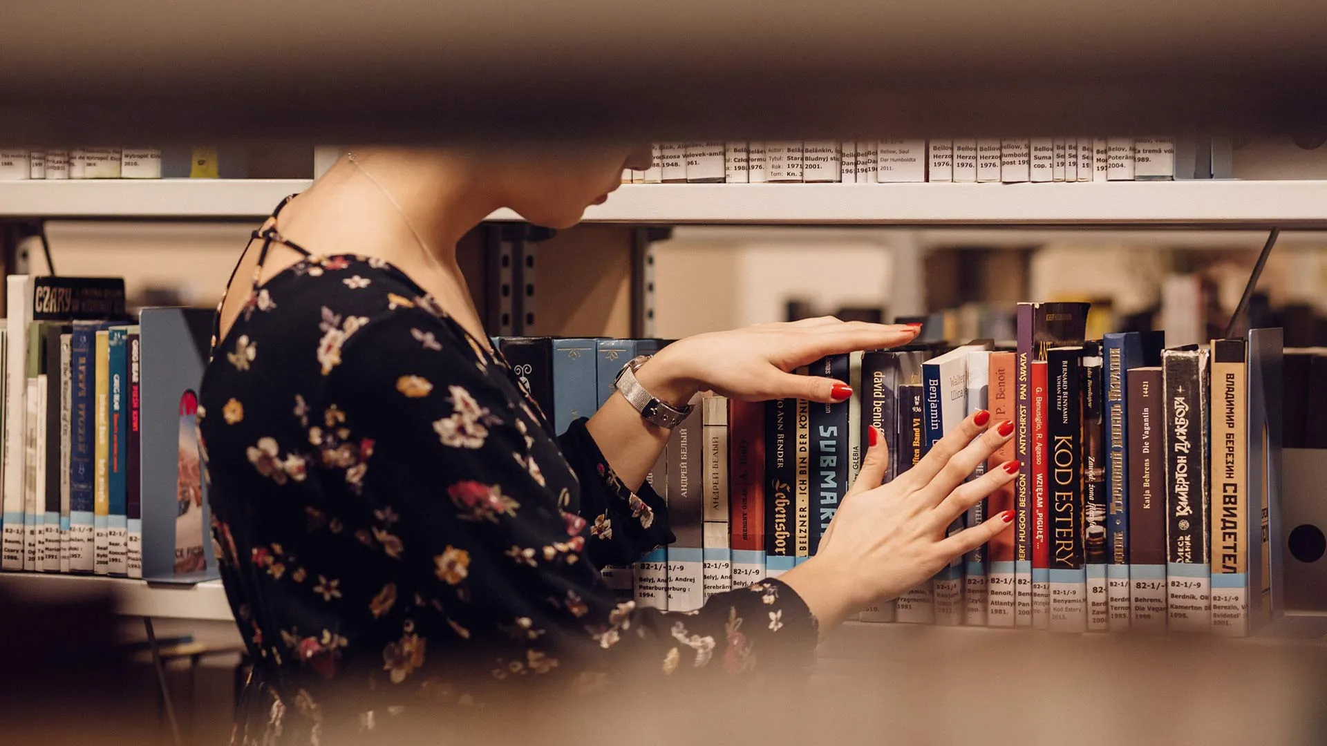 mujer en biblioteca buscando libros
