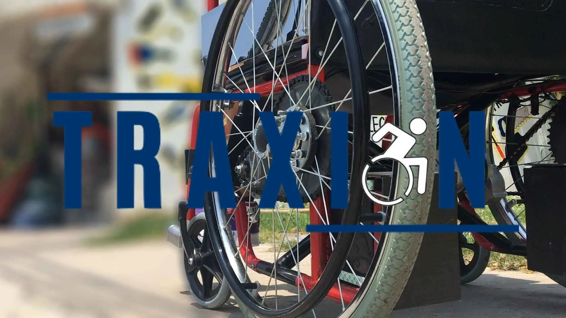 Logo de "Traxión" con el fondo de fotografía de la rueda del silla de ruedas eléctrica