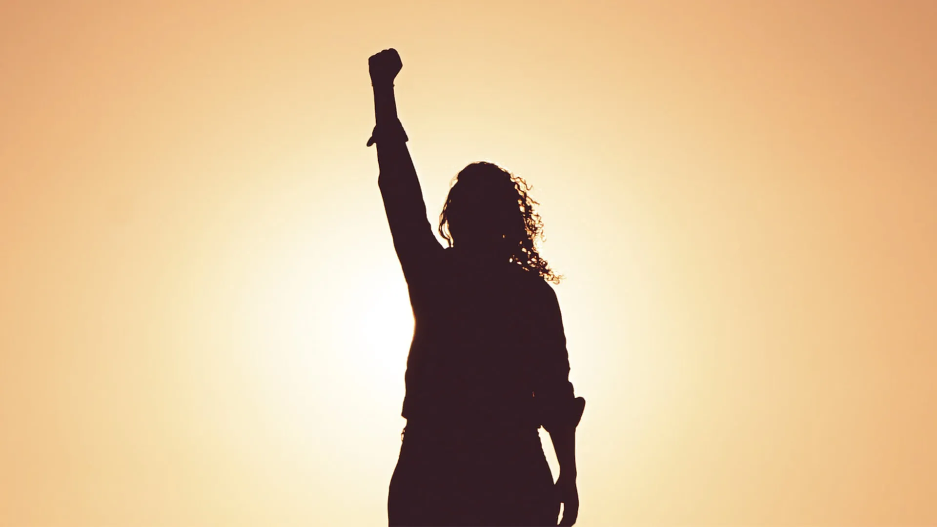 Sombra de mujer alzando la mano contra la violencia de género