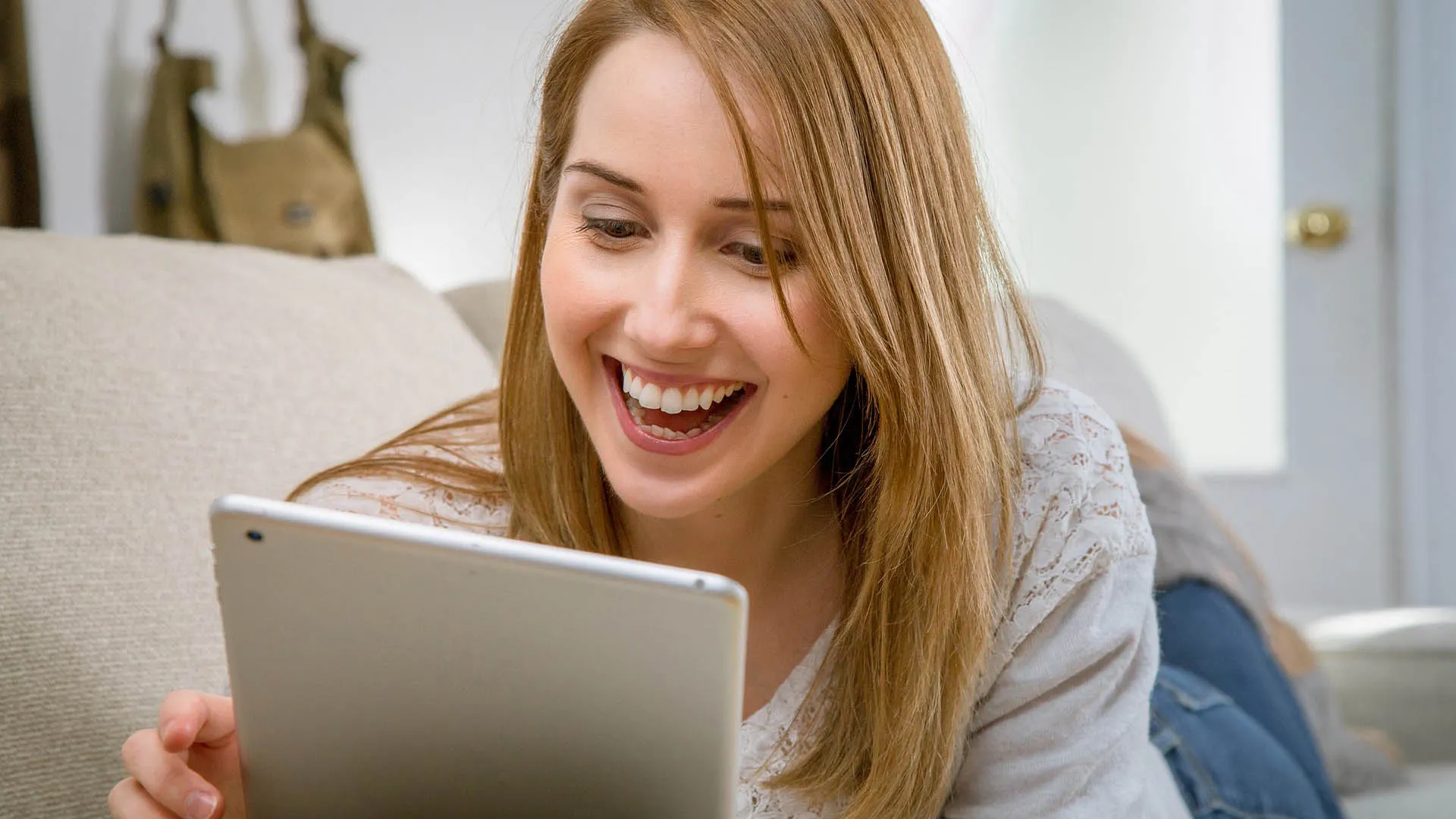 mujer mirando su tablet mientras sonríe
