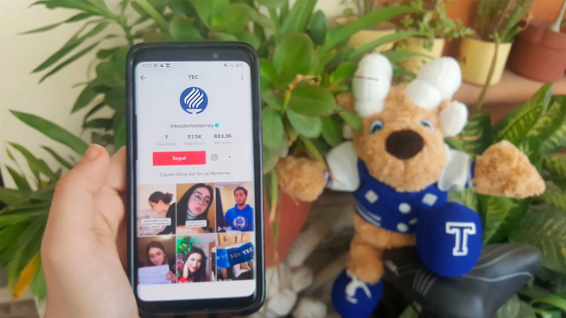 Teléfono móvil con cuenta TikTok del Tecnológico de Monterrey y Teus de fondo