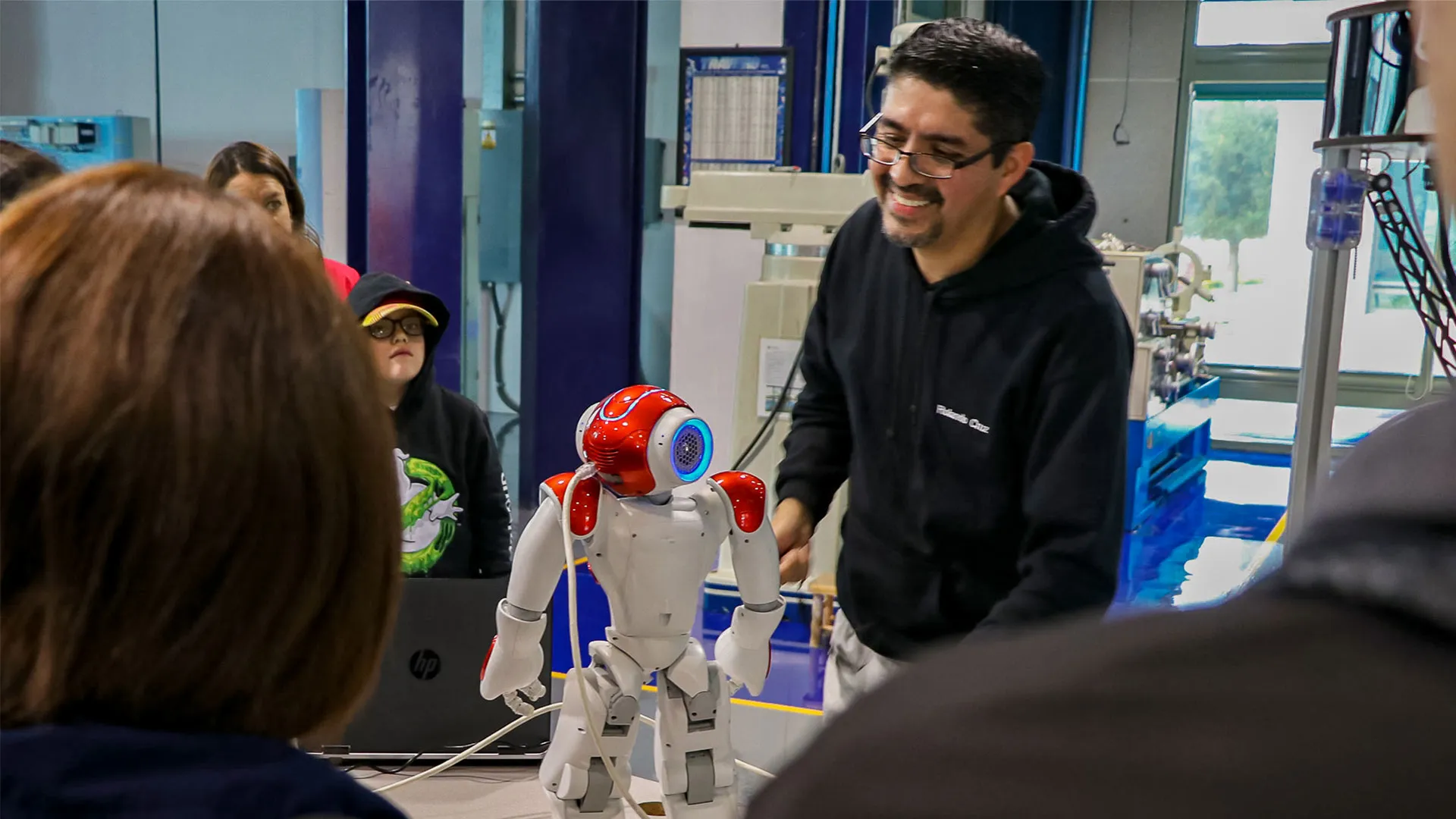 Profesor Rolando Cruz presentando robot NAO frente a estudiantes antes de la pandemia
