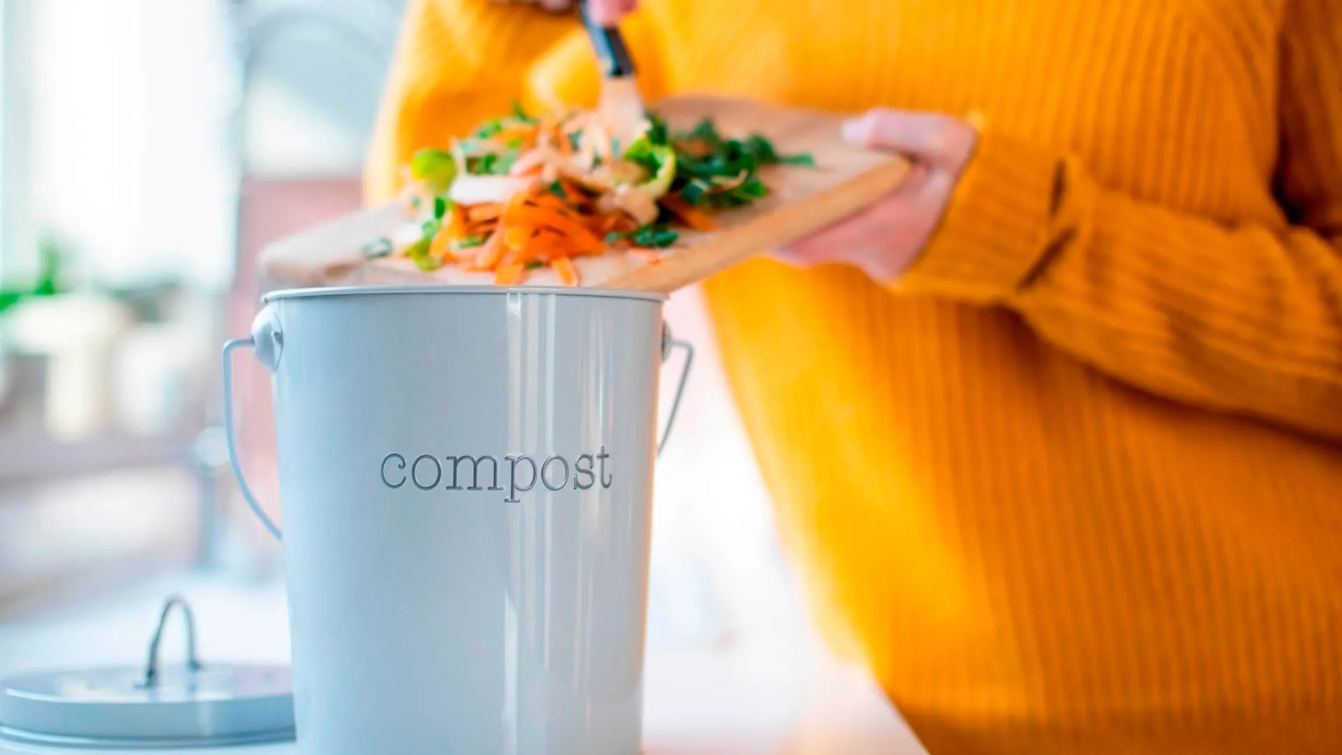 Mujer aprovechando los desechos vegetales de su cocina para hacer composta