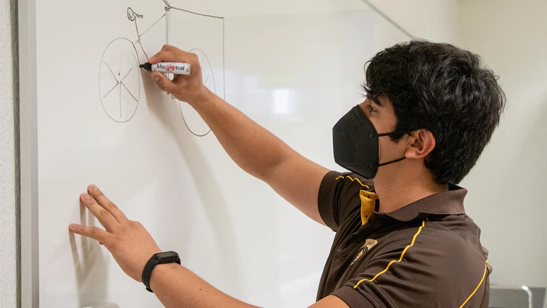 Christian Barush dibujando un triciclo en un pizarrón