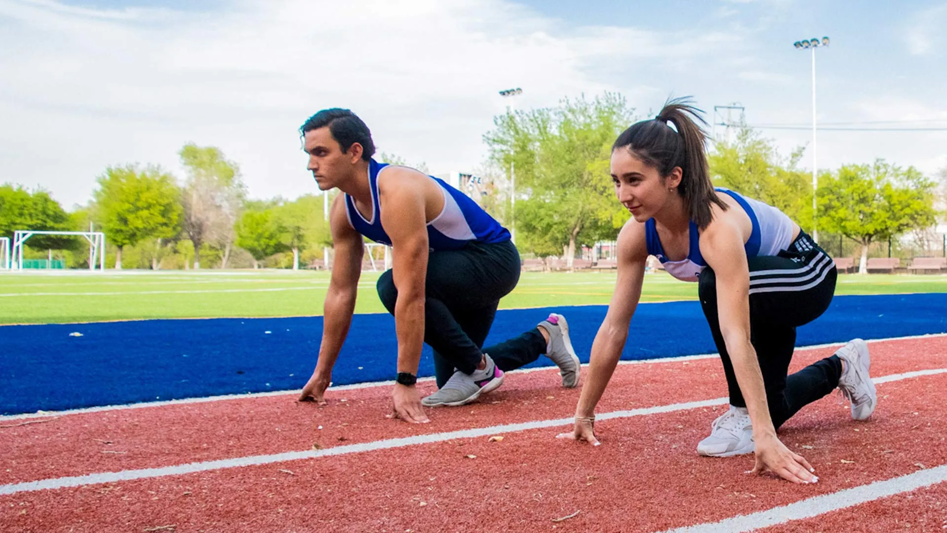 Sofia y Carlos en posición de marcas en la pista de atletismo
