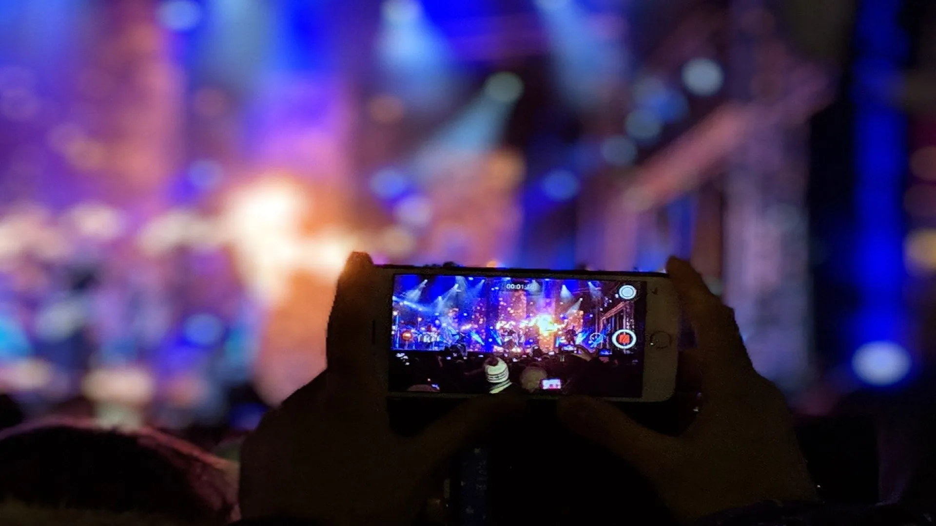 Persona grabando video de concierto en su celular