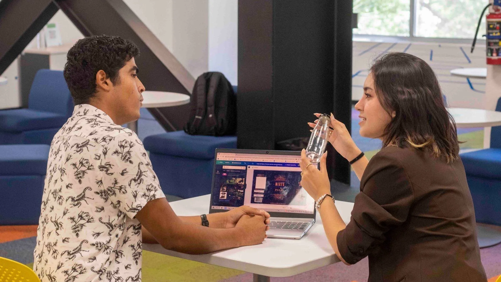 carlos y alicia explicando su proyecto con una computadora
