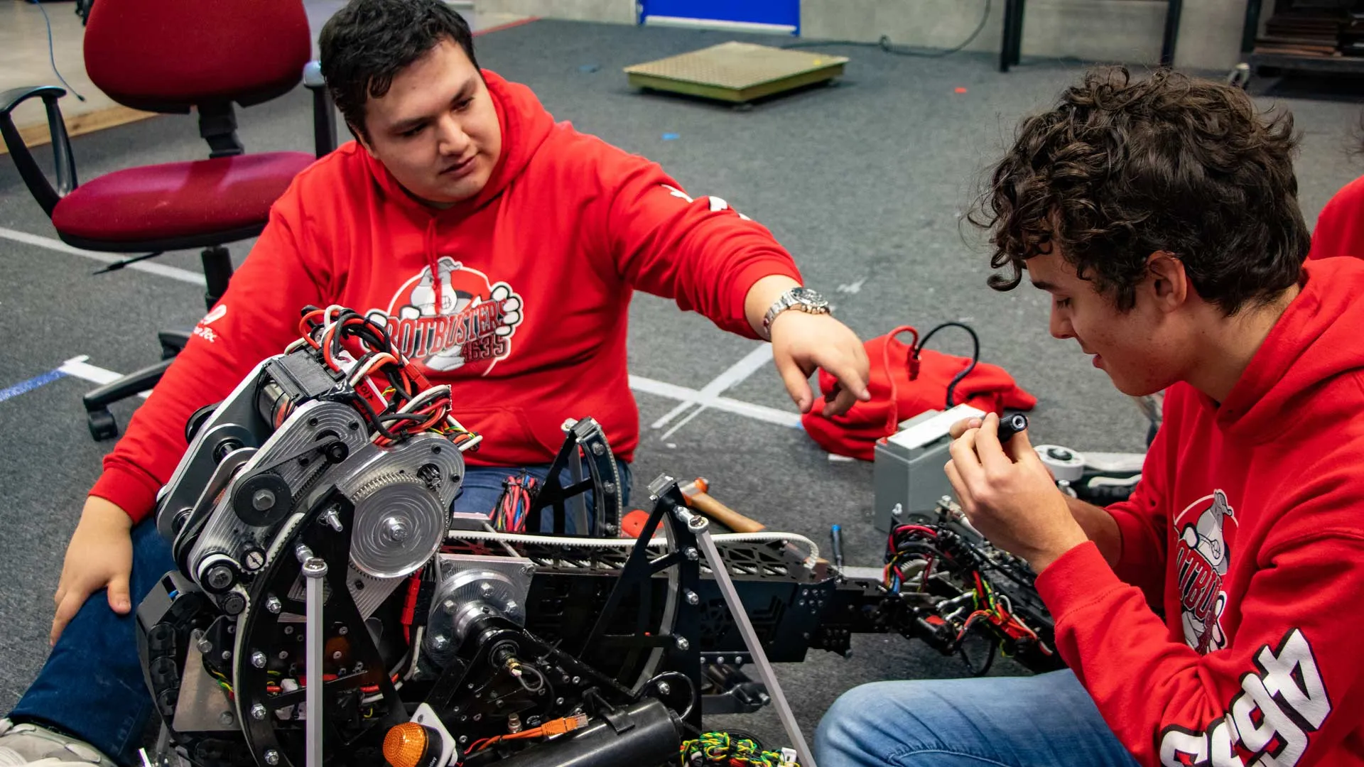 El coach Francisco Rosas ayudando a un estudiante con el robot.