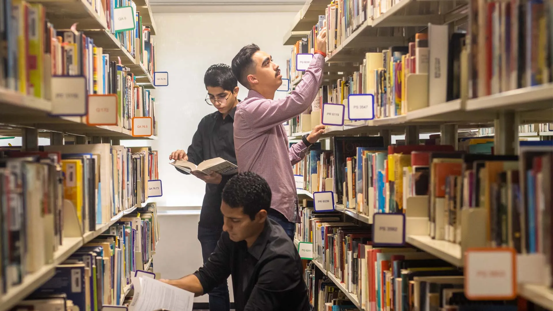 alumnos de ingenieria investigando en biblioteca para su proyecto