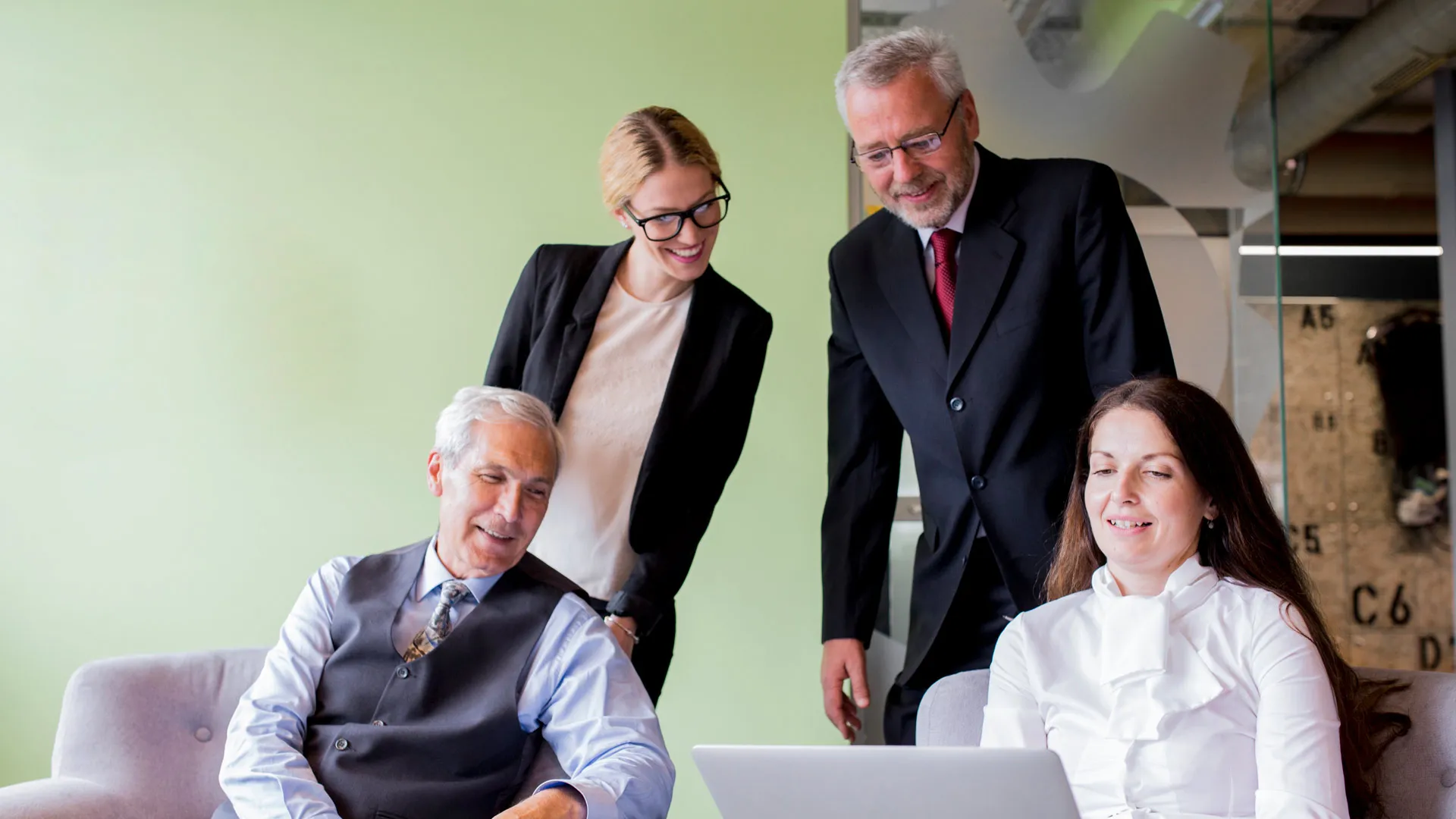 familia empresaria viendo laptop en reunion que busca trascendencia familiar