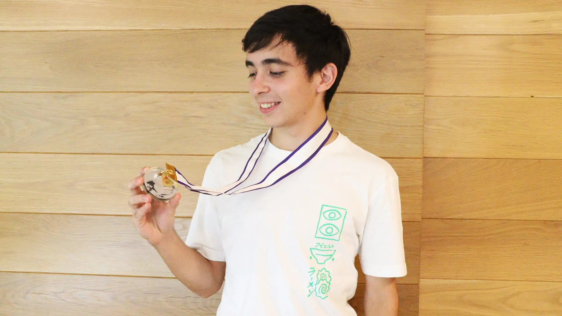 Eric Ransom sosteniendo su medalla de plata obtenida en la Olimpiada Internacional de Matemáticas.