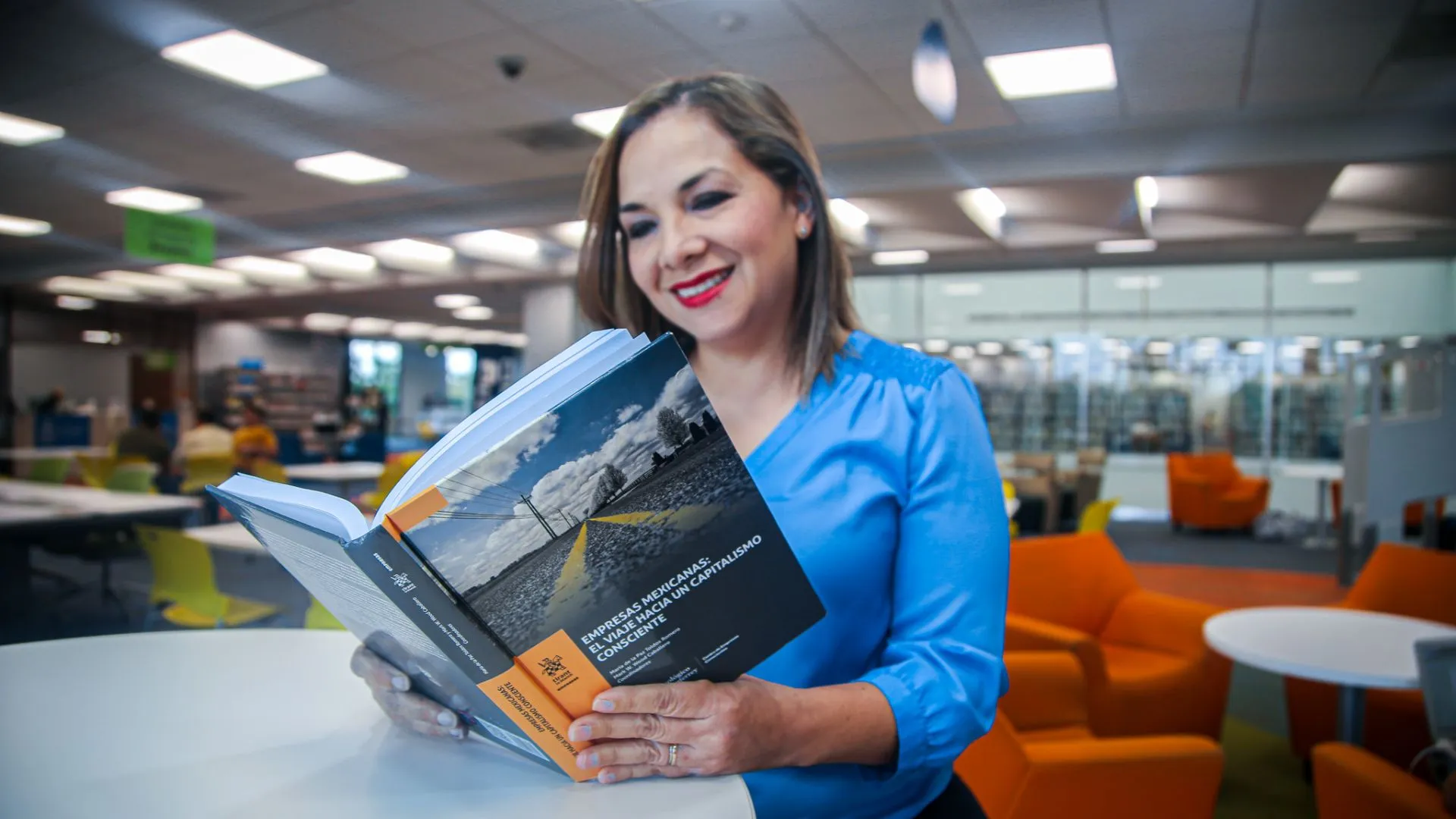 Adriana Morales leyendo un libro en el que participó como coautora