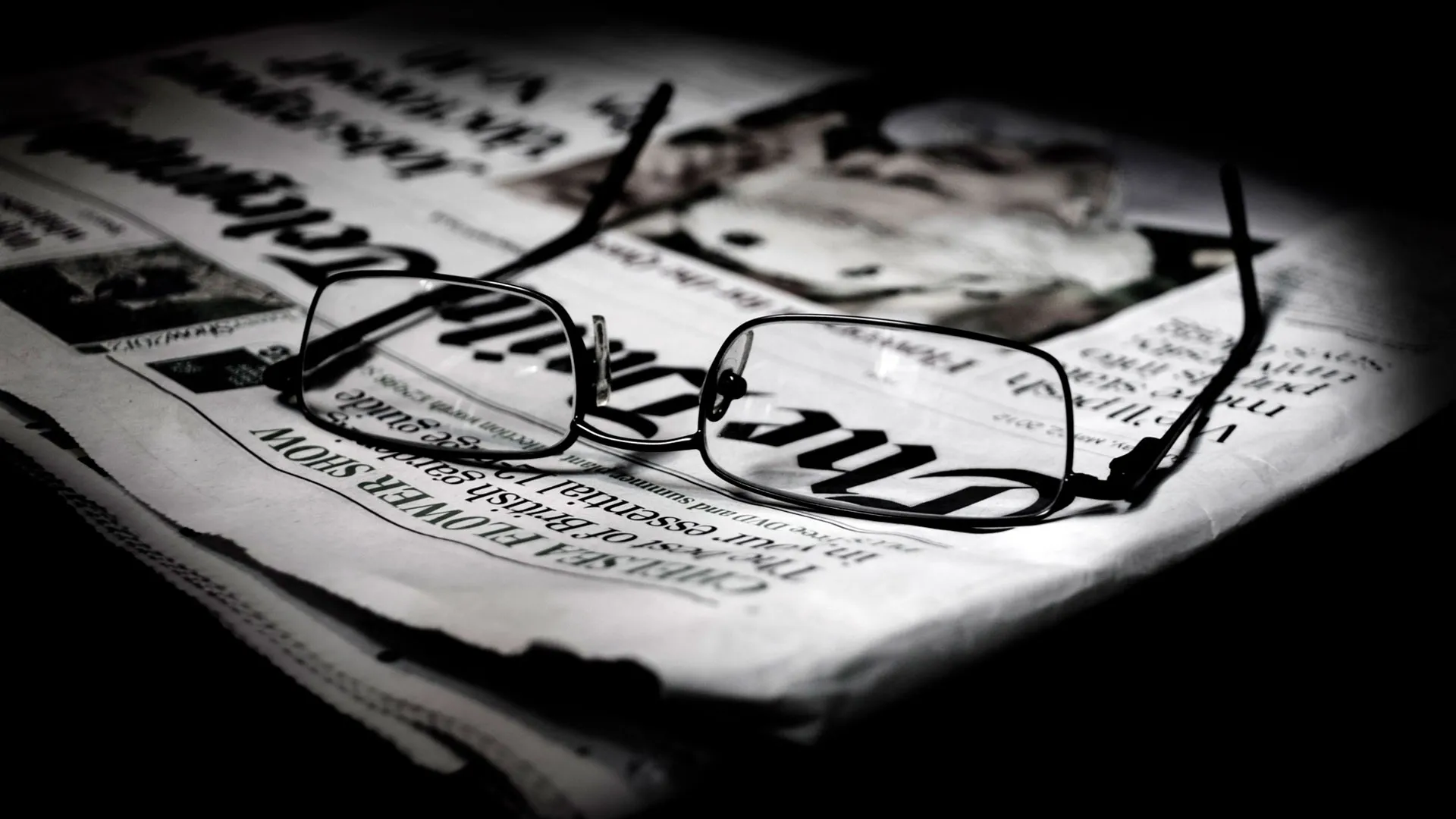 Periódico sobre una mesa con antejos sobre el