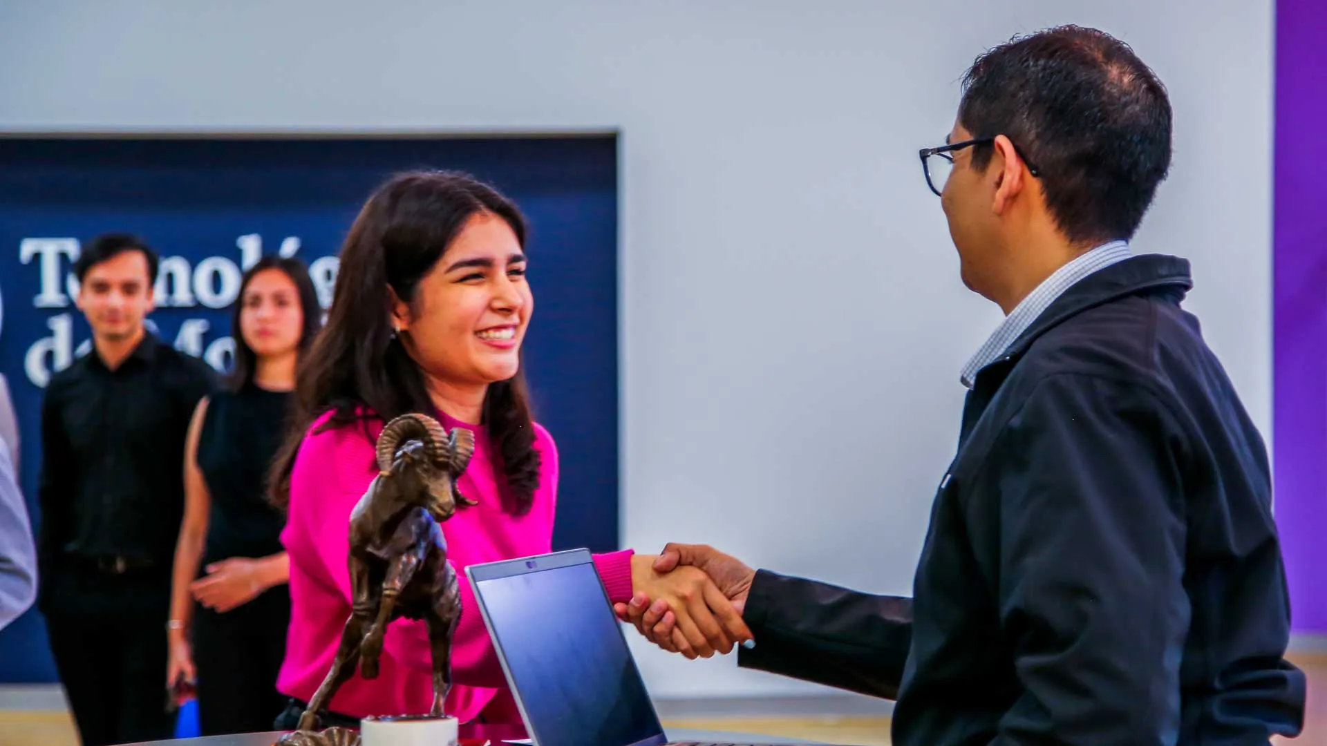Candidata a graduar  de tec tampico saludando a un reclutadores