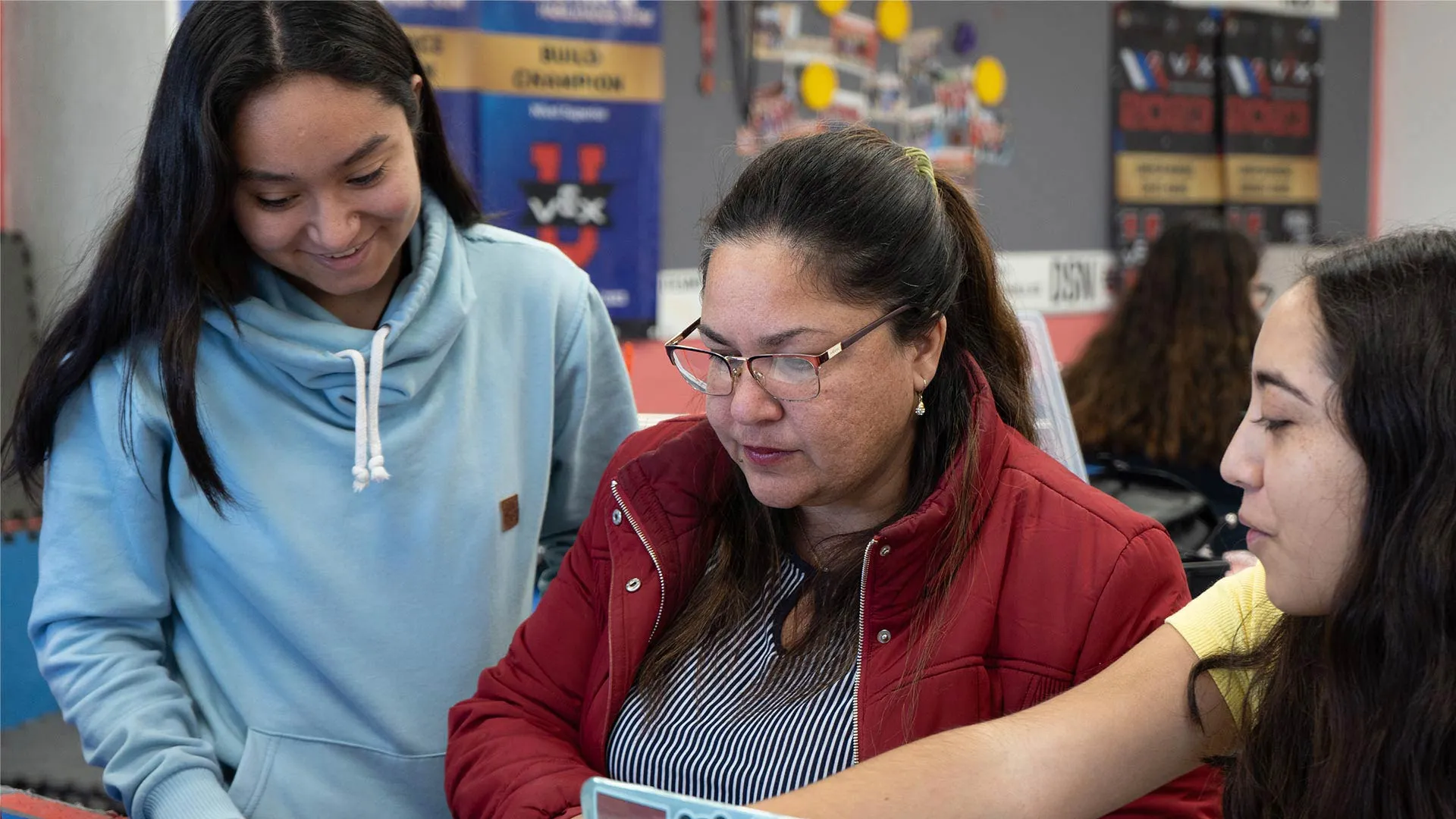 coach con estudiantes trabajando en la computadora