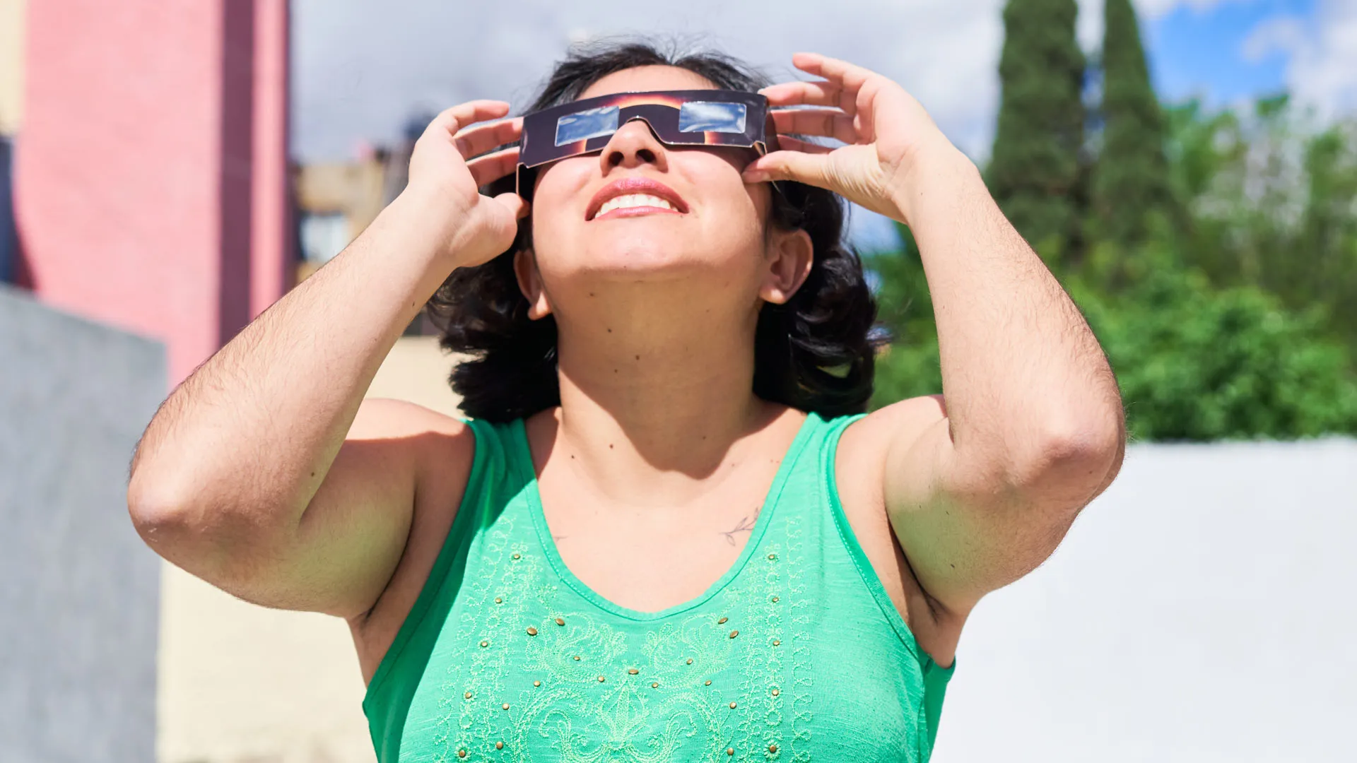 Mujer observa eclipse solar con lentes especiales.
