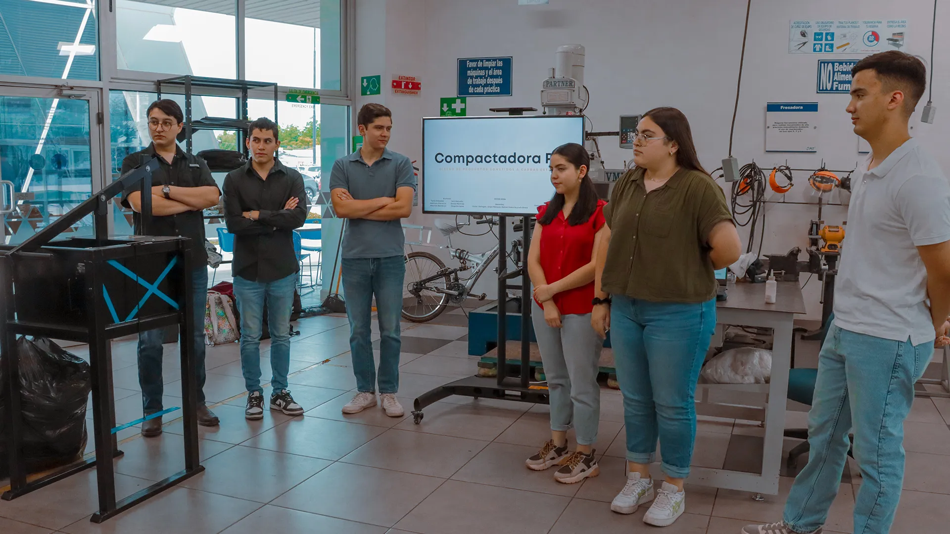 Estudiantes del Tec de Monterrey usando la compactadora de PET