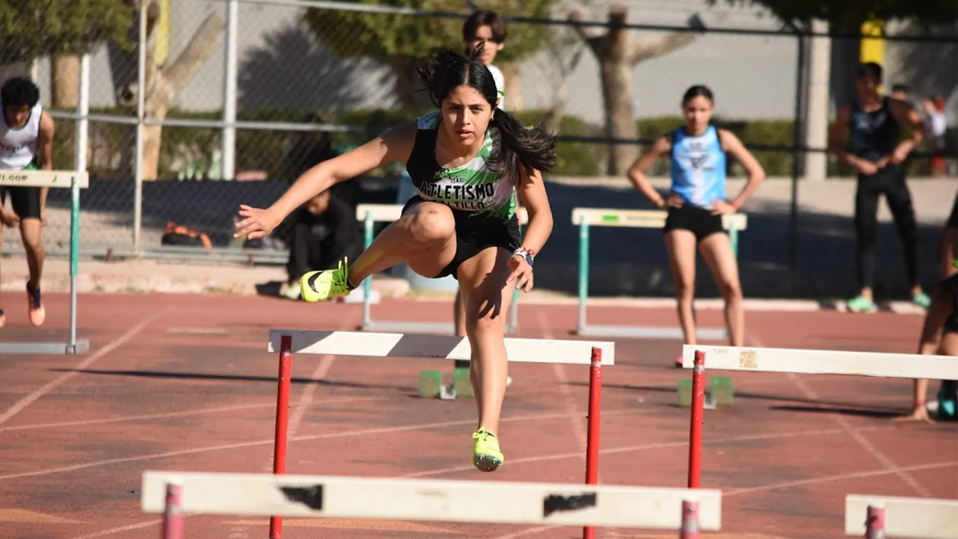 Atleta Tec corriendo en la pista con vallas