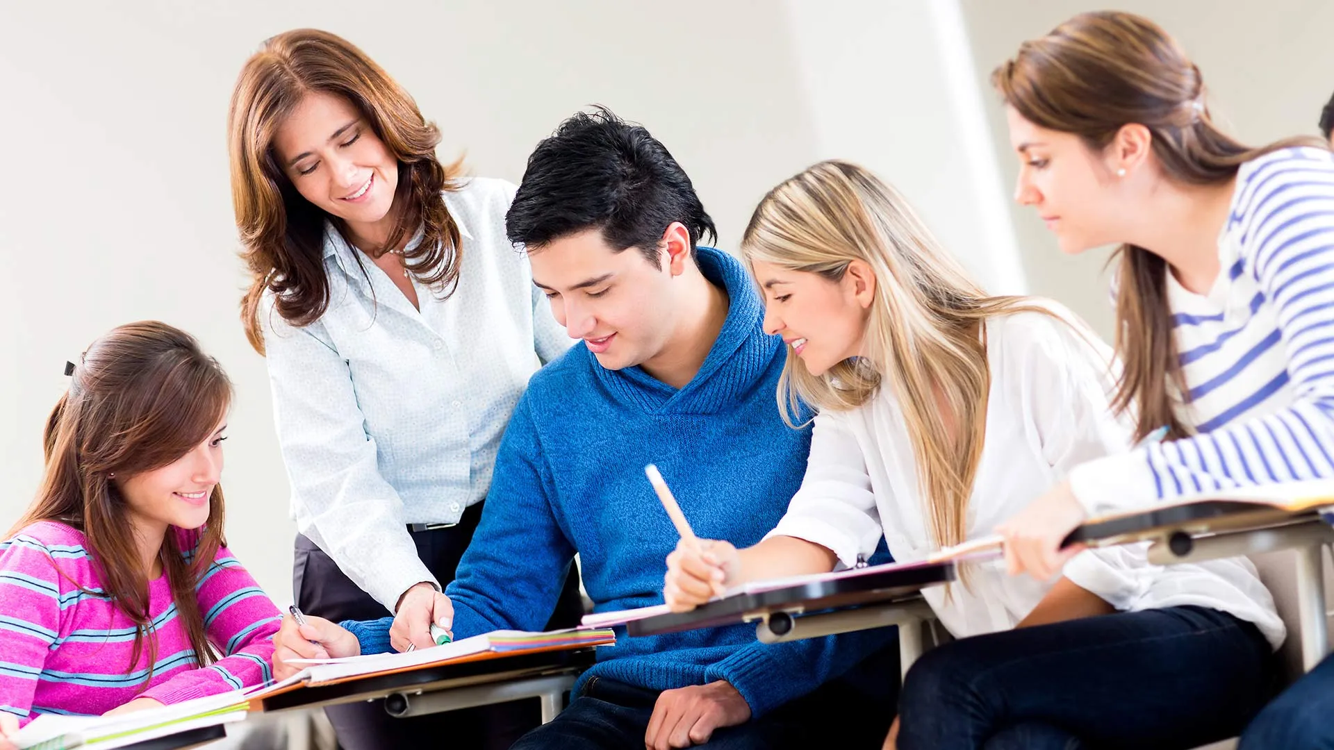 Profesora interactuando con un grupo de 4 alumnos