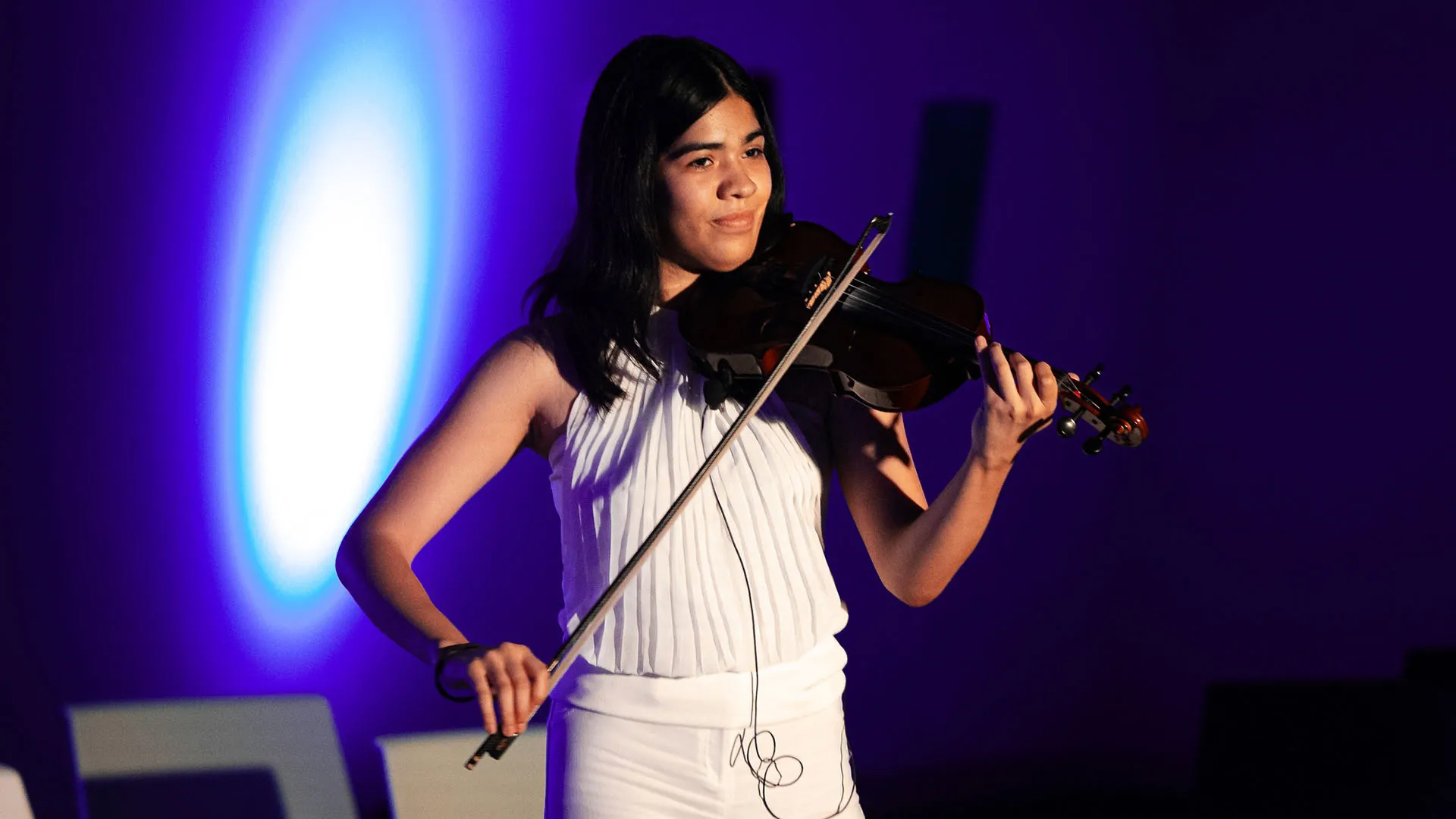 Estudiante del Tec de Monterrey vestida en blanco muestra su talento con la música tocando el violín