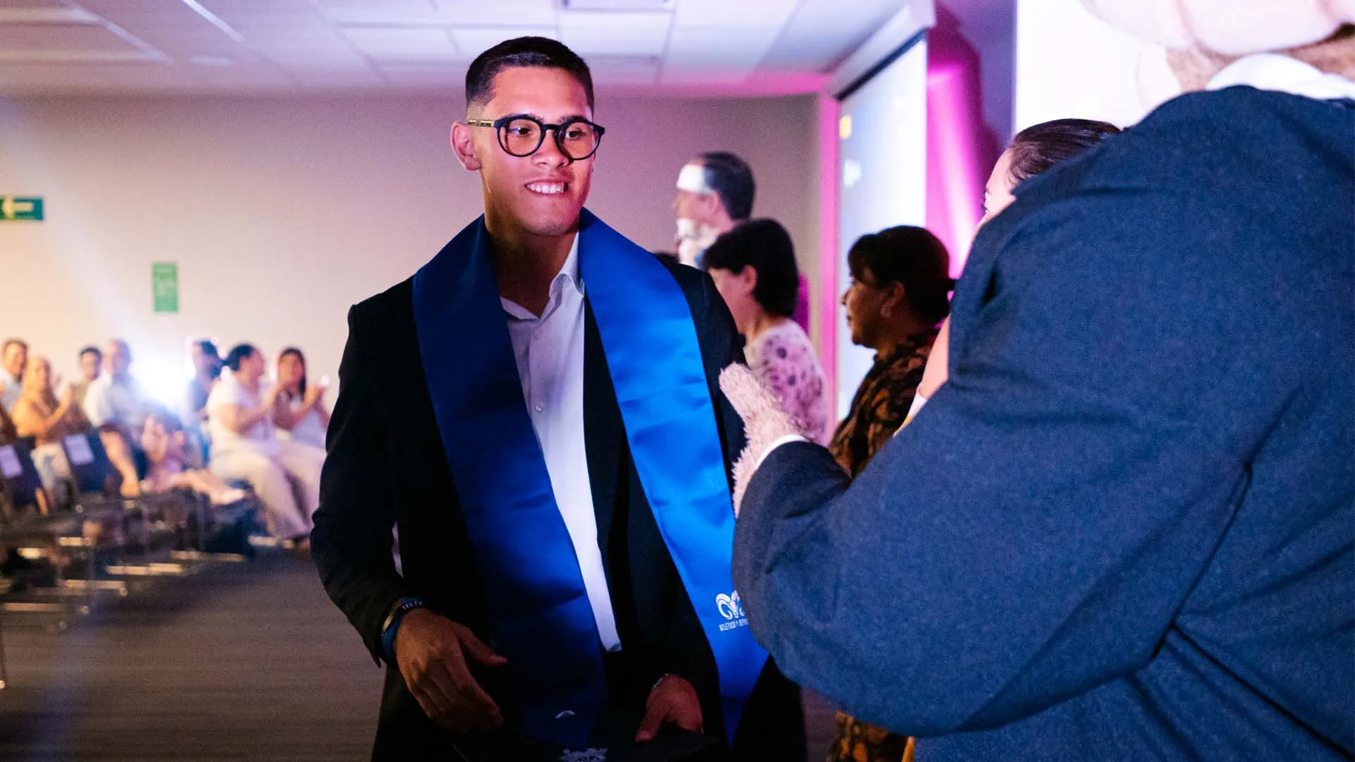 Estudiante de nivel preparatoria porta estola de graduación color azul con el logotipo de Borregos del Tec de Monterrey