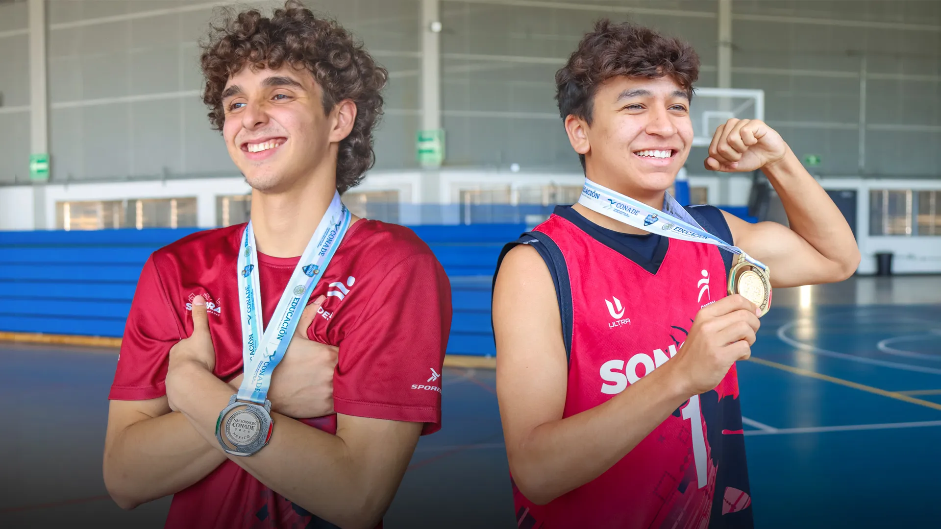 Dos jugadores de basquetbol posando con sus medallas del Nacional CONADEP en la Arena Borregos
